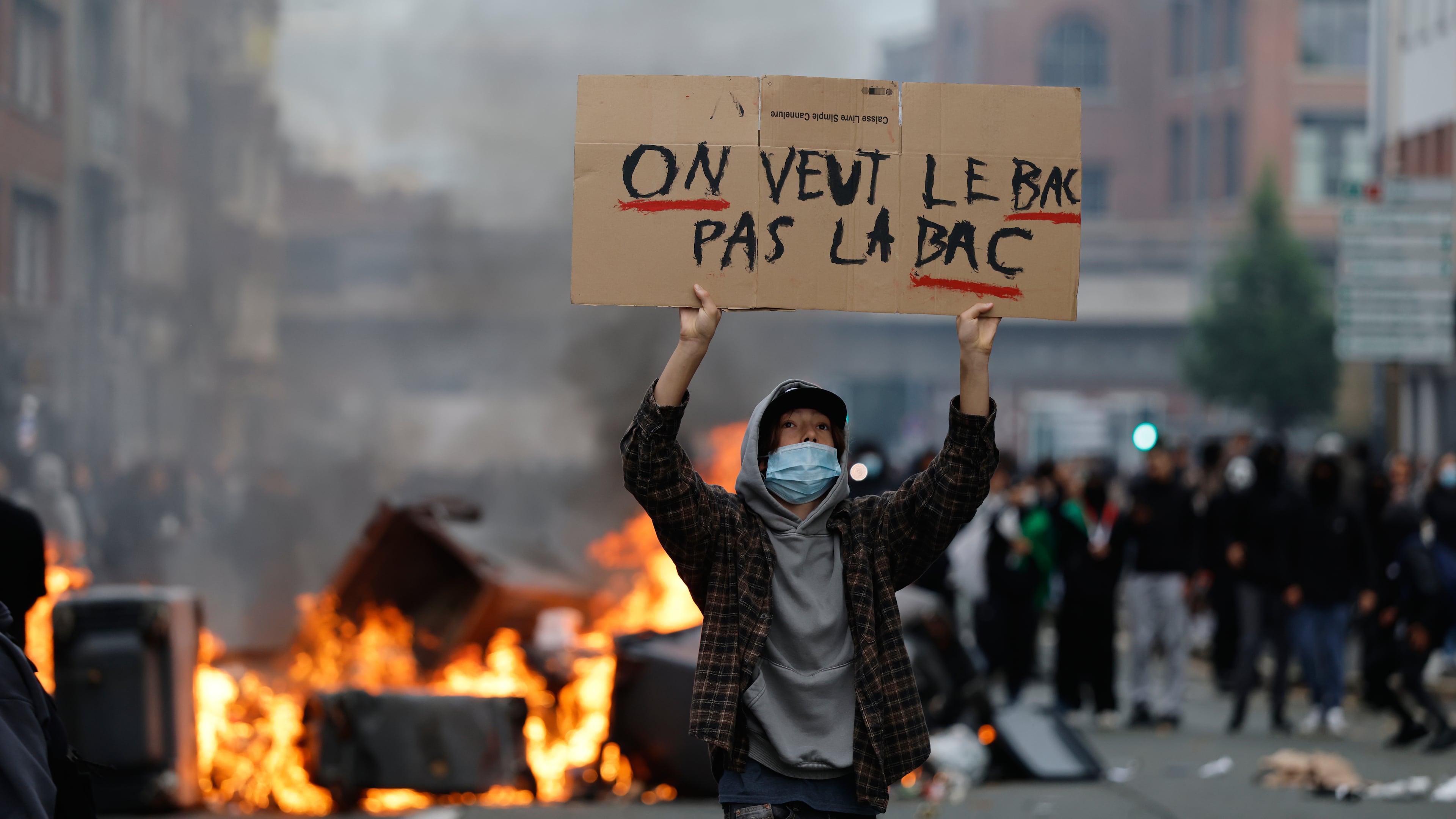 A students holds a board reading, "we want the BAC (High School Diploma) Not the BAC (Anti-criminality units)" during a protest to demand more resources at school, in Lille, France, Thursday, Oct. 1, 2026. (AP Photo/Jean-Francois Badias)