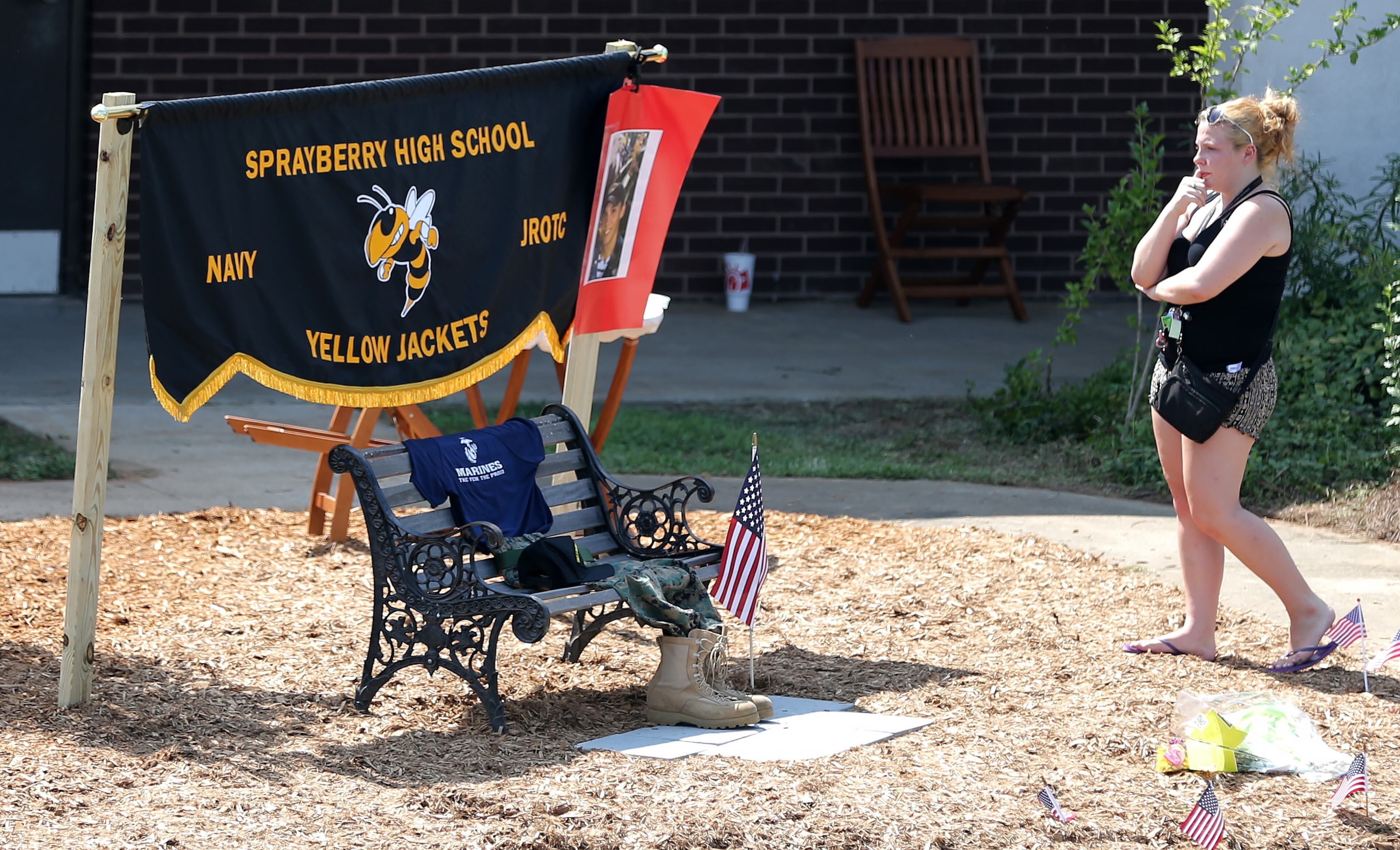 Sarah Hamilton, who was in band with Skip Wells, spends some quiet time at a memorial set up in honor of Skip Wells at Sprayberry High School on Friday afternoon July 17, 2015. Wells, who was one of the Marines killed in Chattanooga, graduated from Sprayberry. Ben Gray / bgray@ajc.com