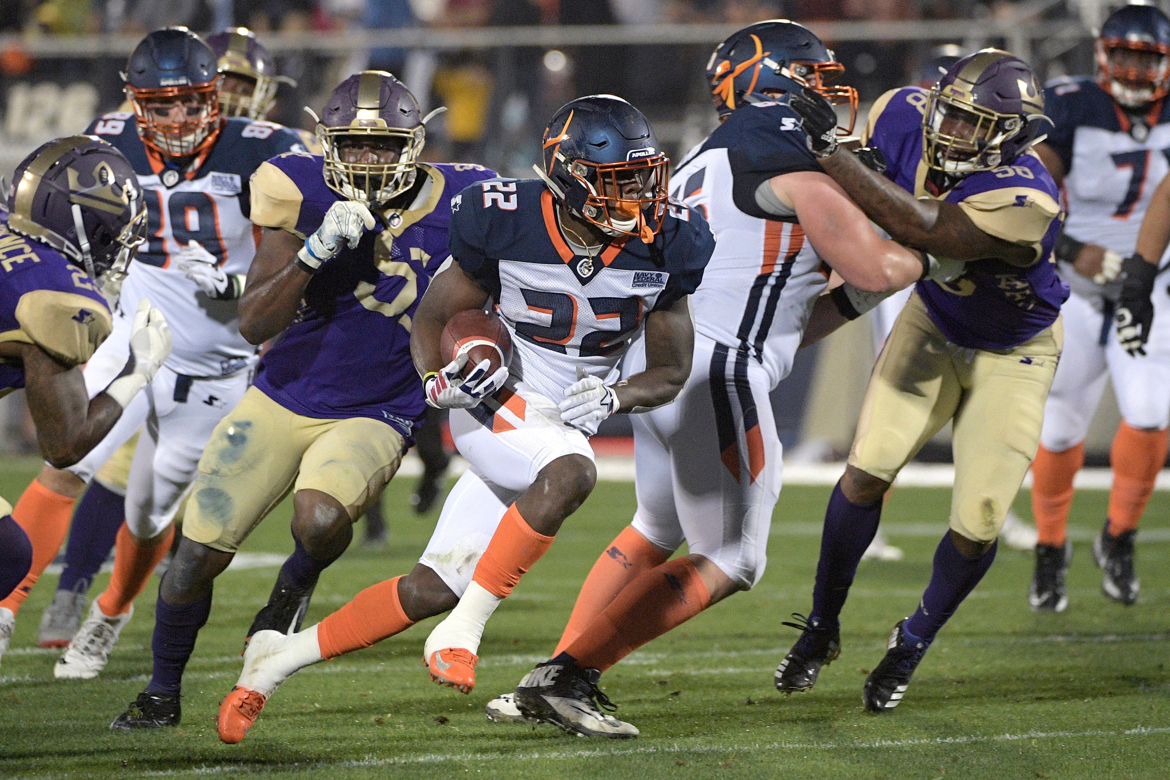 Orlando Apollos running back D'Ernest Johnson (22) rushes for yardage in front of Atlanta Legends defensive back Desmond Lawrence, left, defensive lineman J.T. Jones, center, and linebacker Brandon Watts (58) during the first half of an Alliance of American Football game Saturday, Feb. 9, 2019, in Orlando, Fla. (AP Photo/Phelan M. Ebenhack)