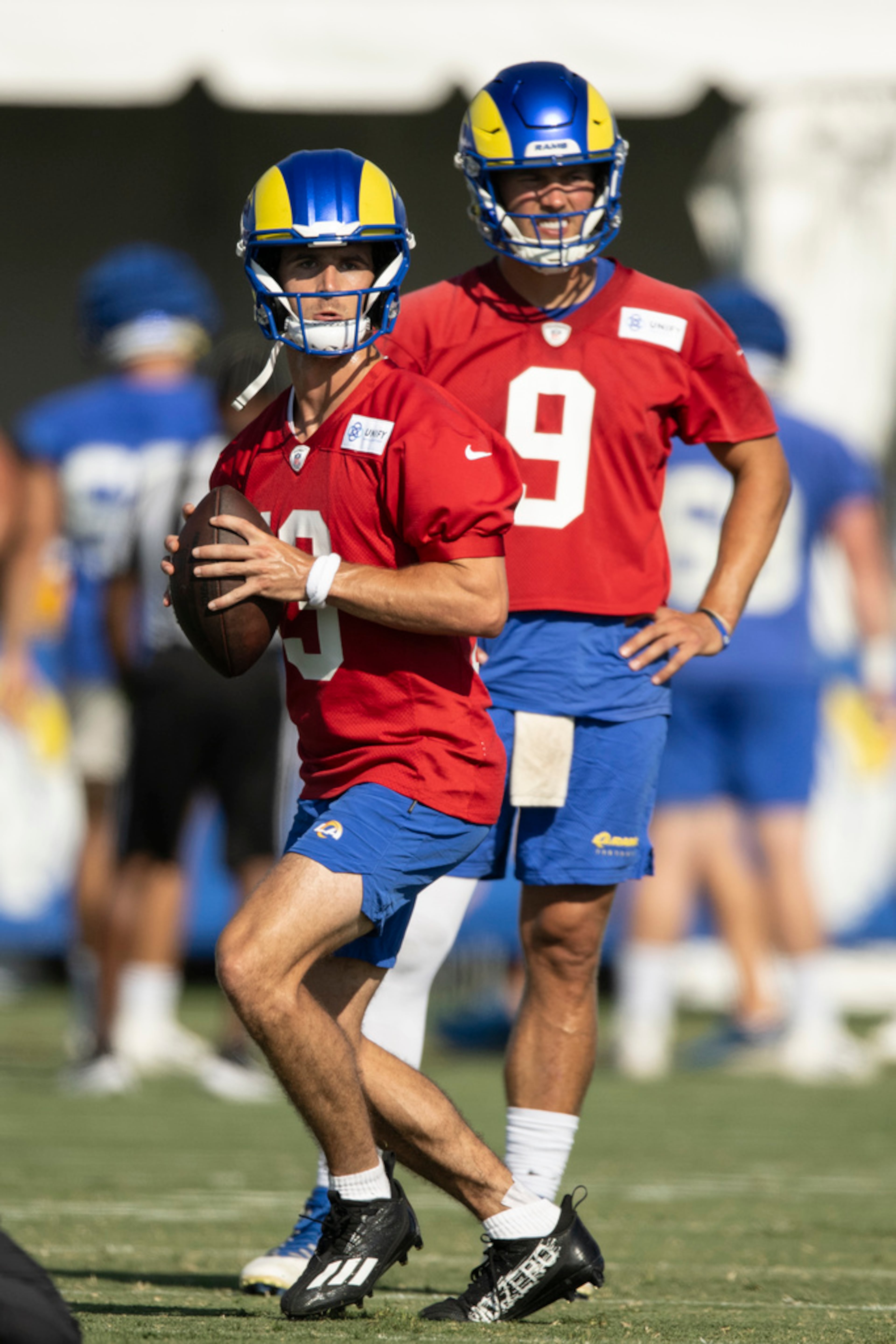 Los Angeles Rams quarterback Stetson Bennett (13) looks to throw a pass as quarterback Matthew Stafford (9) watches him at the NFL football team's training camp, Saturday, July 29, 2023, in Irvine, Calif. (AP Photo/Kyusung Gong)