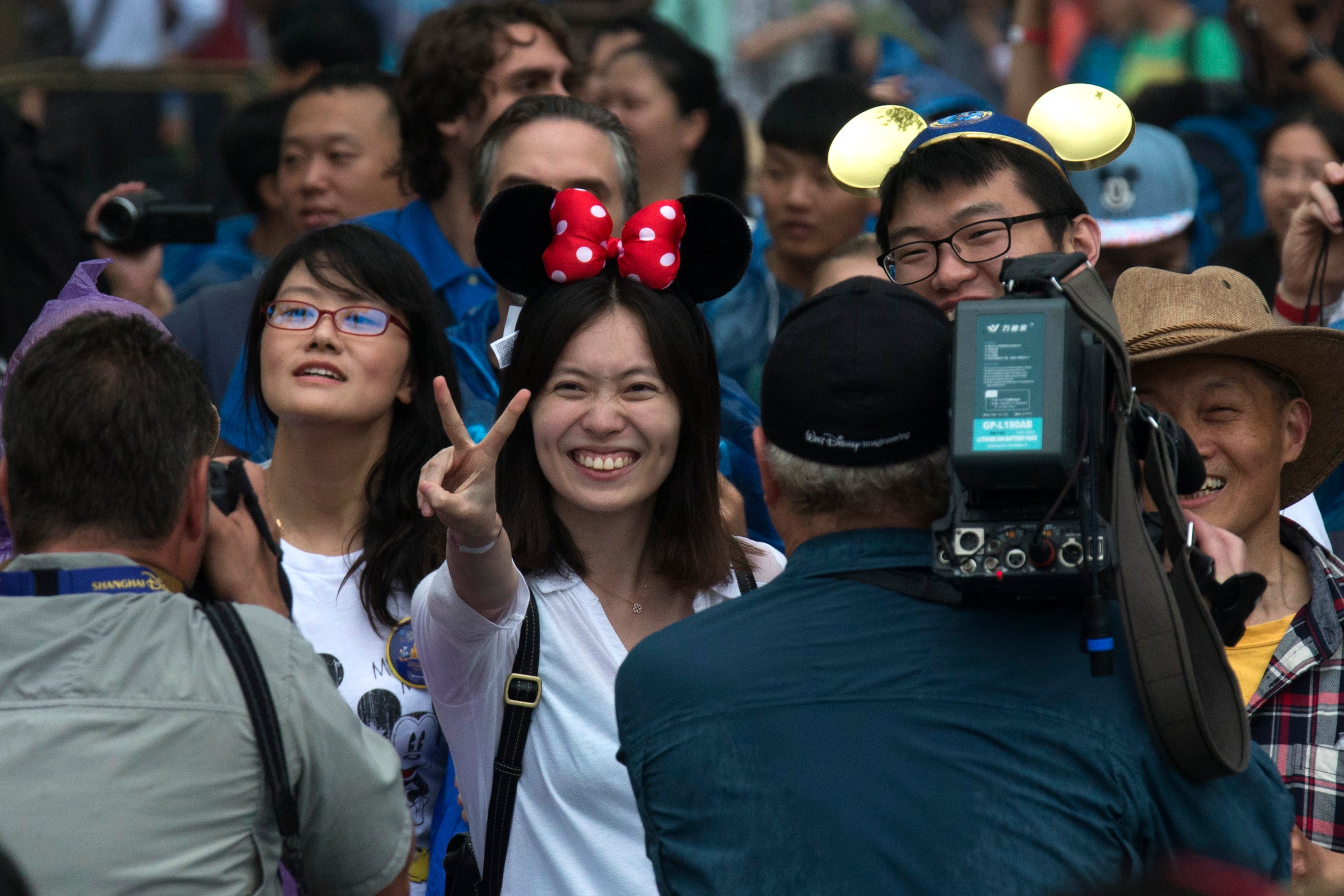 Visitors react on opening day of the Disney Resort in Shanghai, China, Thursday, June 16, 2016. Walt Disney Co. opened its first theme park in mainland China on Thursday at a ceremony that mixed speeches by Communist Party officials, a Chinese children's choir and actors dressed as Sleeping Beauty and other Disney characters. (AP Photo/Ng Han Guan)