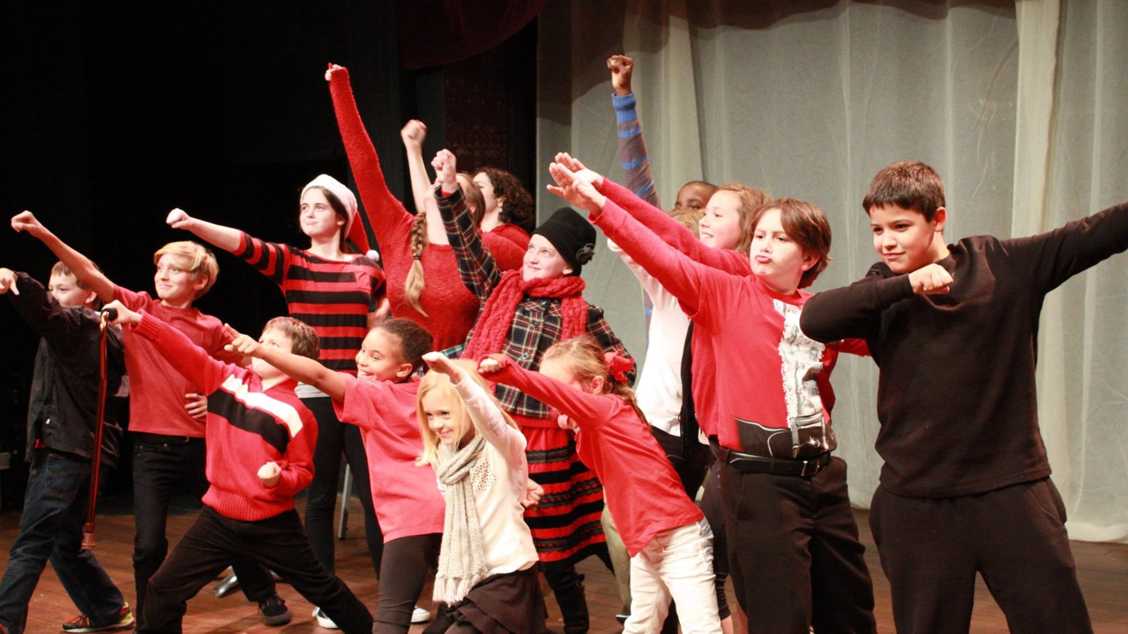 Schoolchildren on the stage at Aurora Theatre. The theatre is asking supporters to wear red to the Lawrenceville city council meeting Jan. 7 in support of the Lawrenceville Performing Arts Center Campus Expansion. Courtesy Aurora Theatre