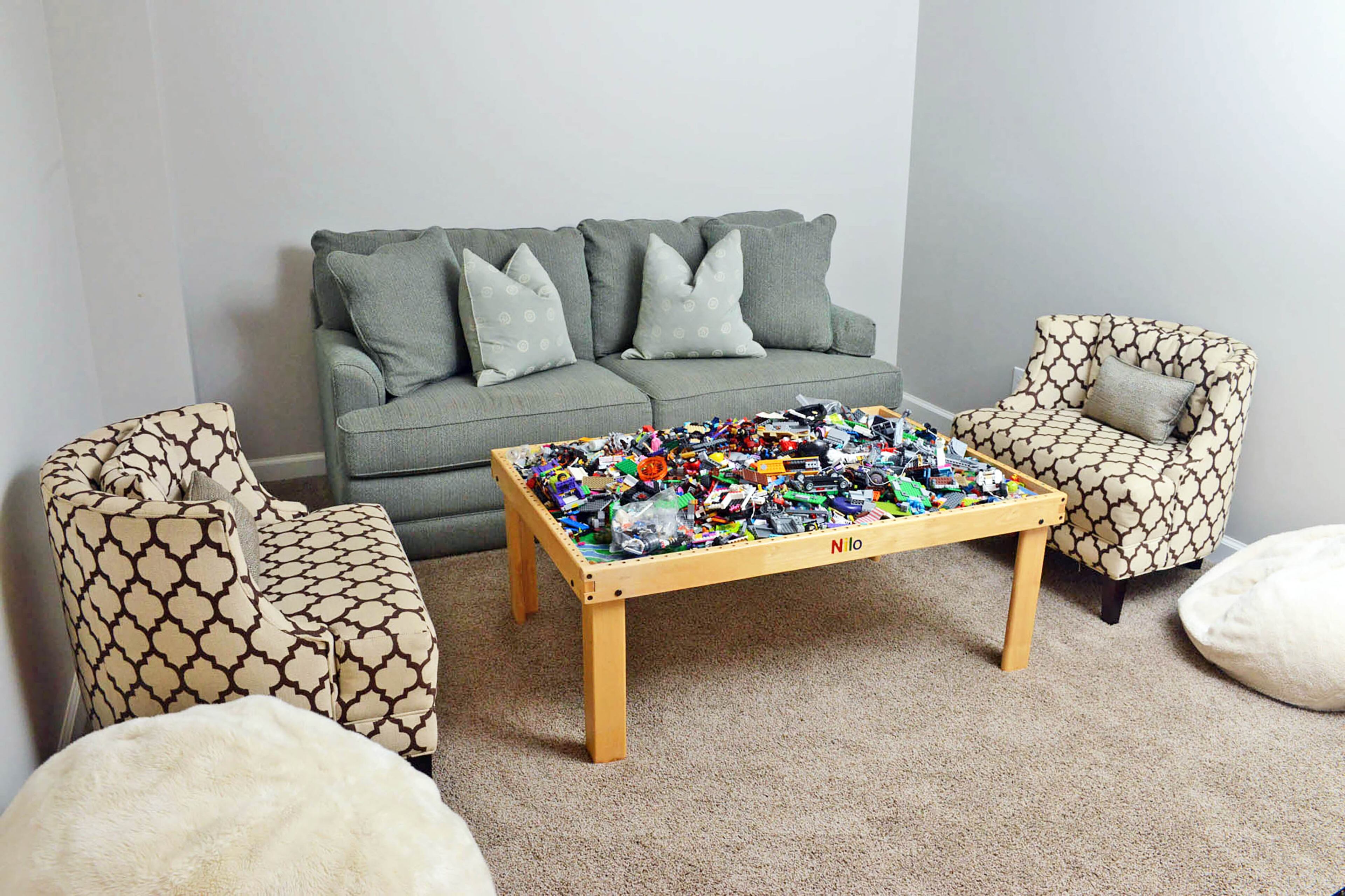 The finished basement has a relaxed family vibe, with a Lego table and soft, inviting seating.