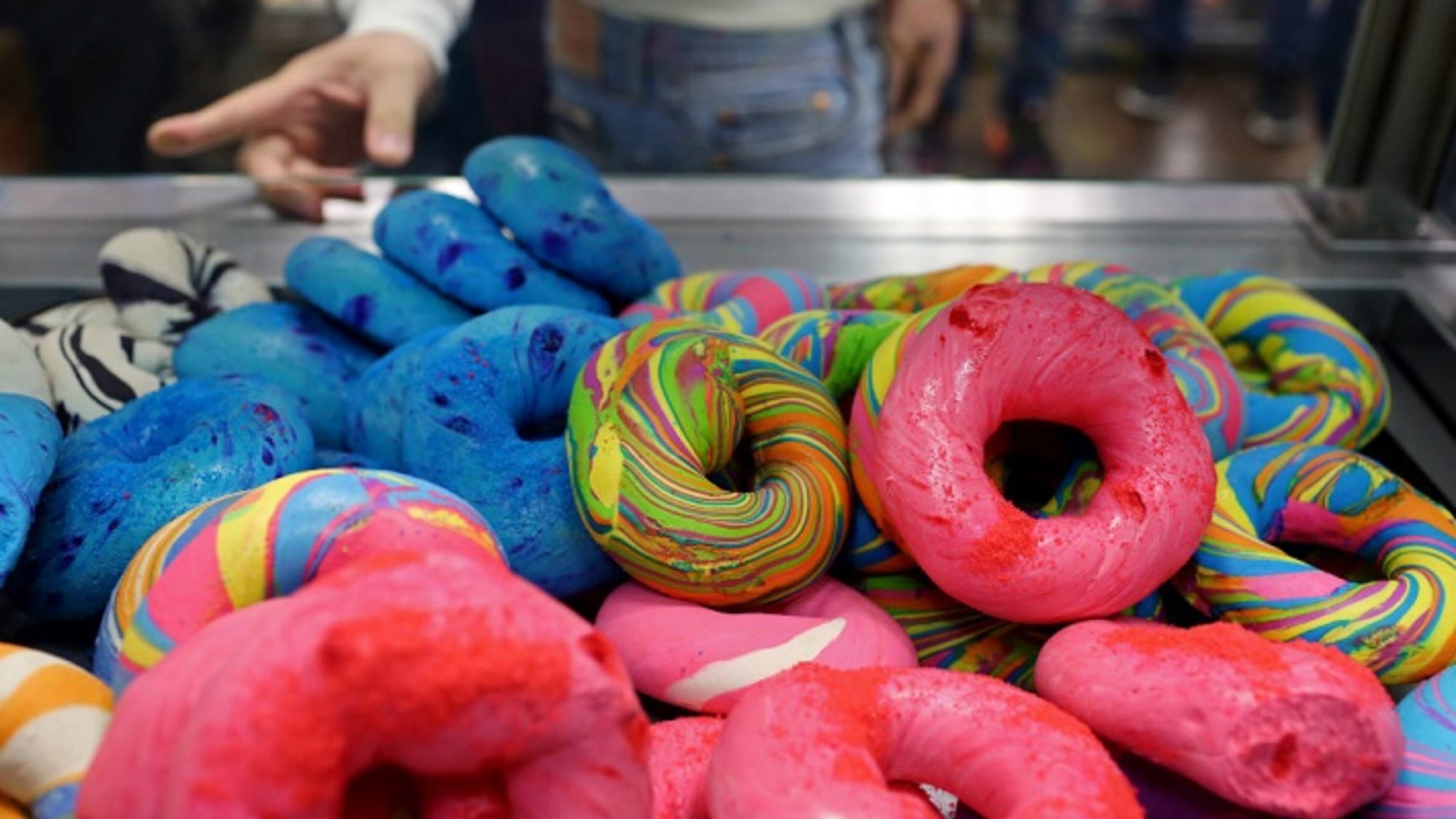 Customers check out rainbow bagels at The Bagel Store in Brooklyn. Rainbow bagels represent a new form of gentrification. MUST CREDIT: Photo for The Washington Post by Yana Paskova.