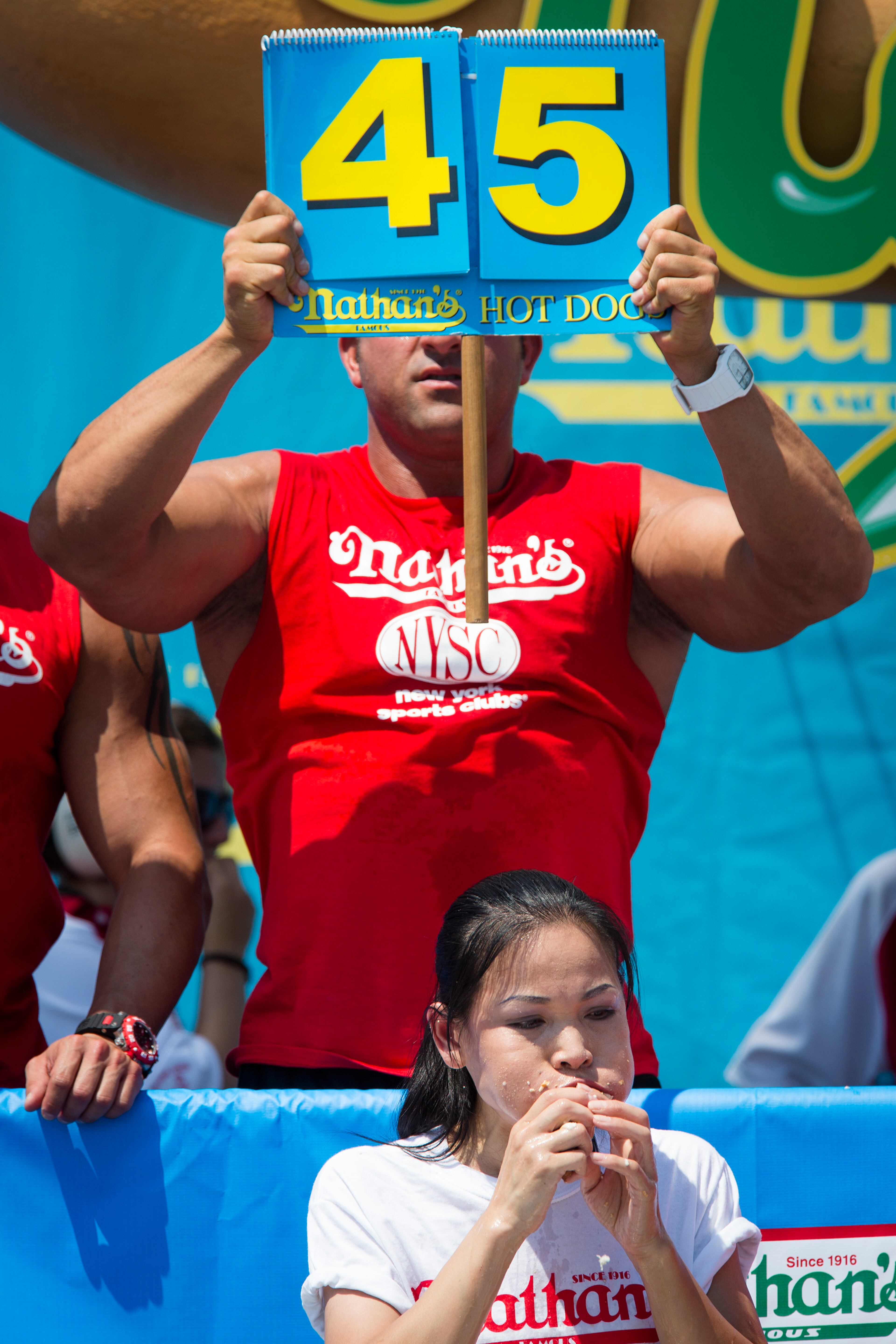 Sonya "The Black Widow" Thomas breaks her world record during the Nathan's Famous Women's Hot Dog Eating World Championship, Wednesday, July 4, 2012, at Coney Island, in the Brooklyn borough of New York. Thomas beat her own record by gobbling down 45 hot dogs and buns in 10 minutes to win the women's competition at the annual Coney Island contest. (AP Photo/John Minchillo)