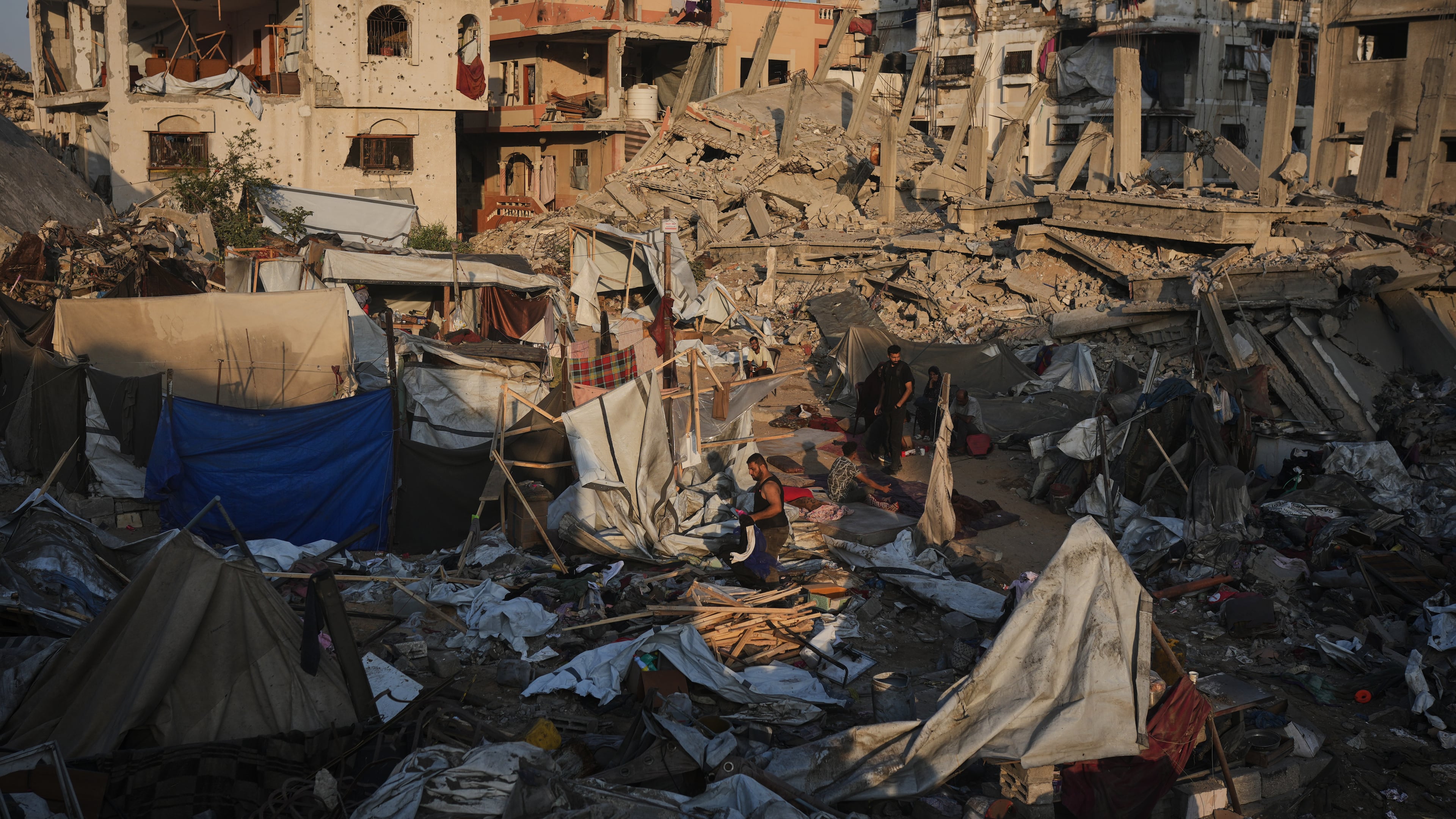 Palestinians salvage their belongings from the rubble of a building and tents destroyed in an Israeli airstrike in Gaza City, Thursday, July 30, 2026. (AP Photo/Jehad Alshrafi)