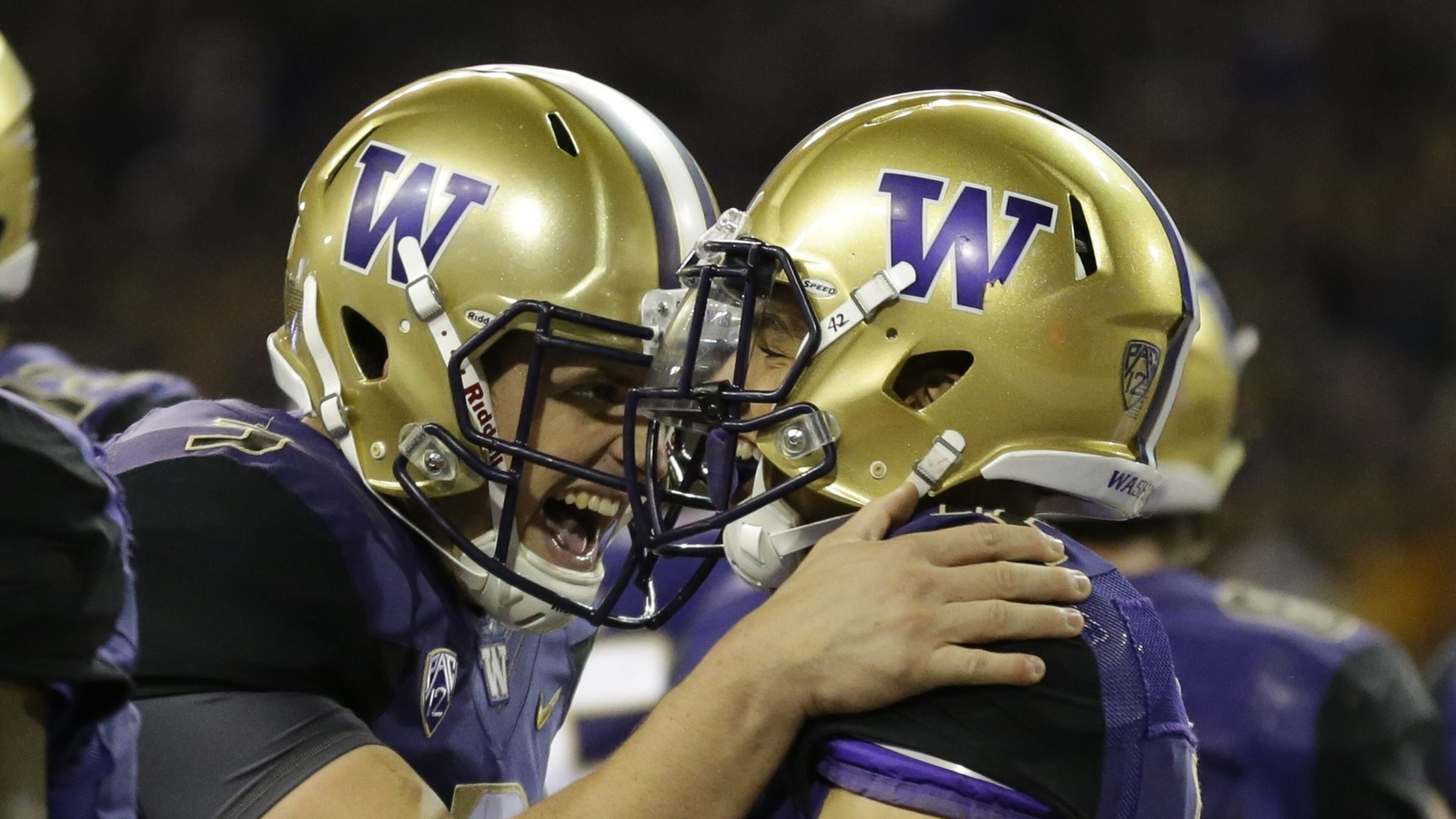 Washington quarterback Jake Browning (left) celebrates with wide receiver Aaron Fuller after Fuller caught a touchdown pass from Browning earlier this season. (AP Photo/Ted S. Warren, File)