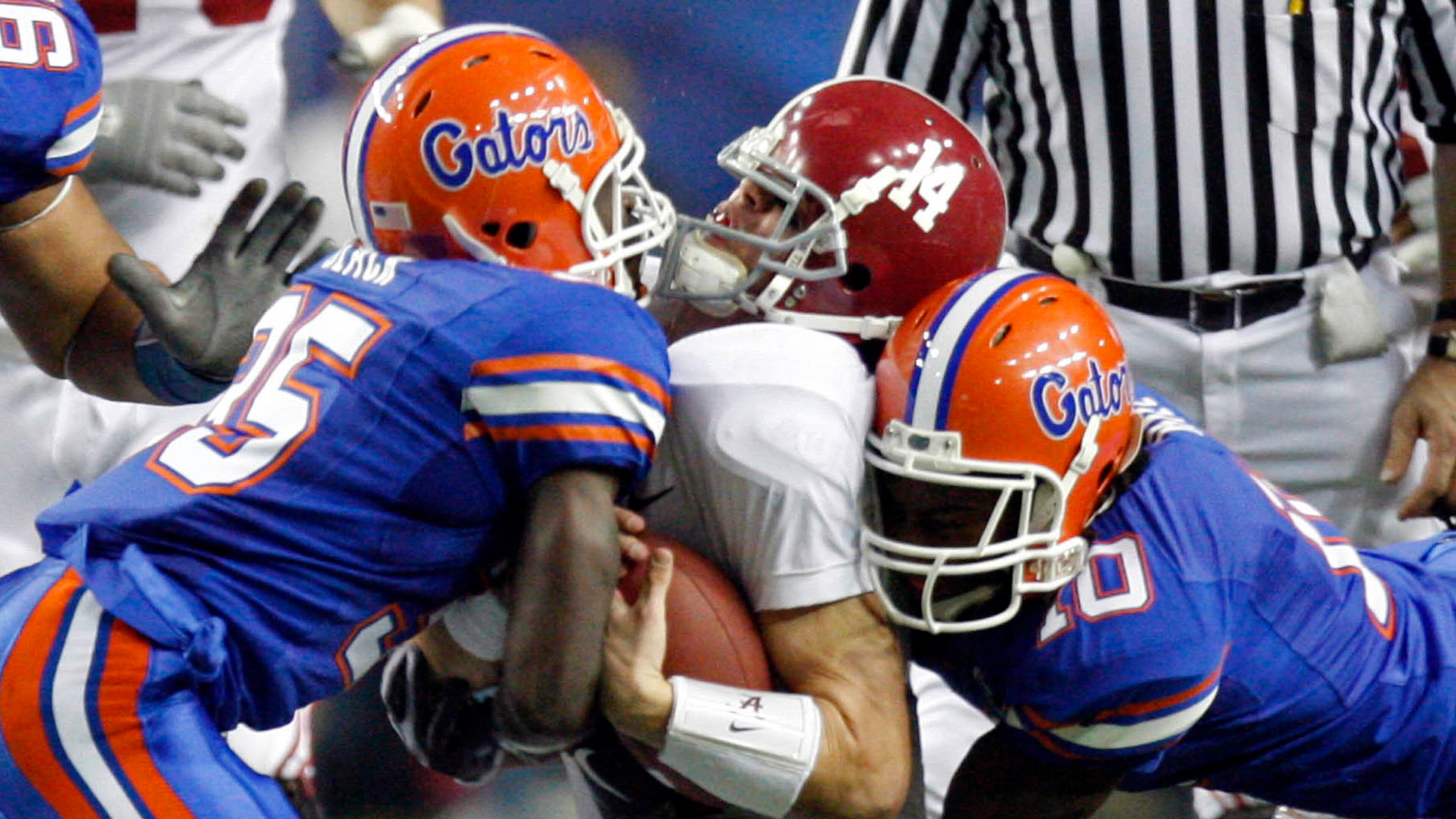 081206 Atlanta--Florida safety Ahmad Black (35, left) and Florida safety Will Hill (10, right) sandwich Alabama quarterback John Parker Wilson (14) on a run in the second half of Florida's 31-20 win over Alabama in the SEC Championship game Saturday afternoon in the Georgia Dome in Atlanta, Ga., December 6, 2008. JASON GETZ / jgetz@ajc.com