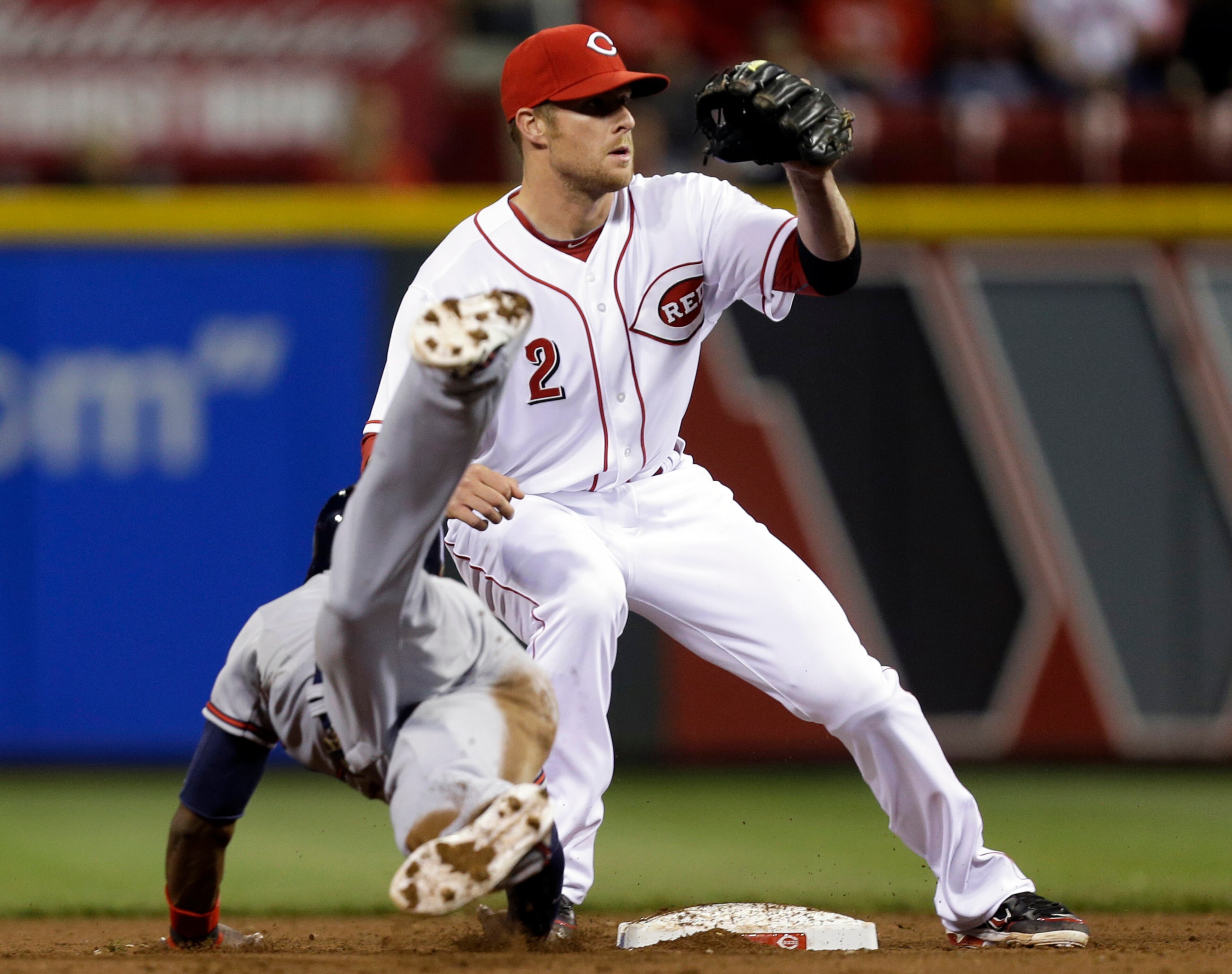 Braves' B.J. Upton dives safely back to second as Reds' shortstop Zack Cozart (2) catches a pick-off throw in the fifth inning in Cincinnati.