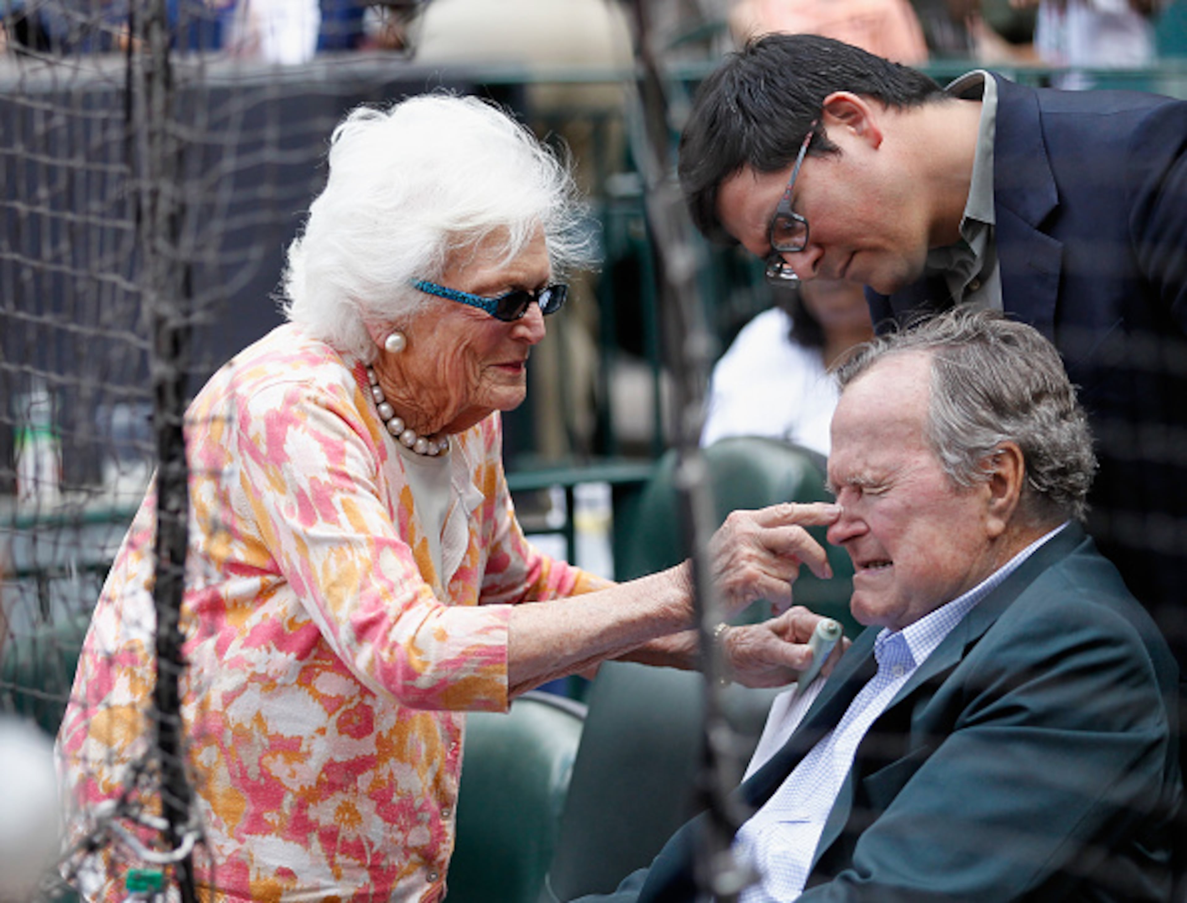 HOUSTON, TX - MAY 03: Former President George H.W. Bush receives some sun screen as they get ready to watch the Seattle Mariners play the Houston Astros at Minute Maid Park on May 3, 2015 in Houston, Texas. (Photo by Bob Levey/Getty Images)