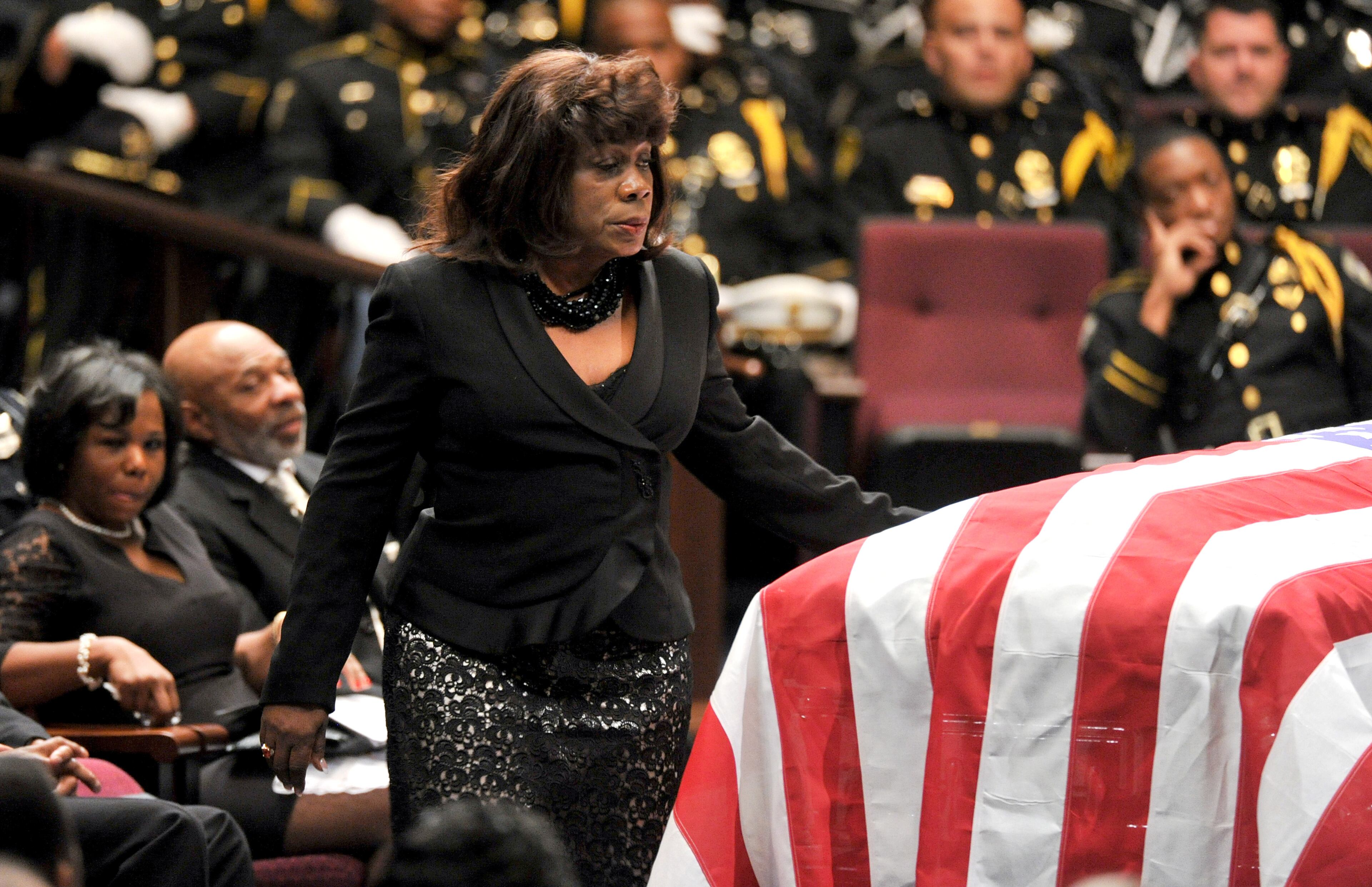 APD Officer Shawn Smiley's mother Carol Smiley touches the casket as she walks to the podium to speak during APD Officer Shawn Smiley's funeral at First Baptist Church of Atlanta on Saturday, November 10, 2012. APD Officer Shawn Smiley was in the passenger seat last weekend when an APD helicopter searching for a missing 9-year-old boy crashed in Atlanta. HYOSUB SHIN / HSHIN@AJC.COM
