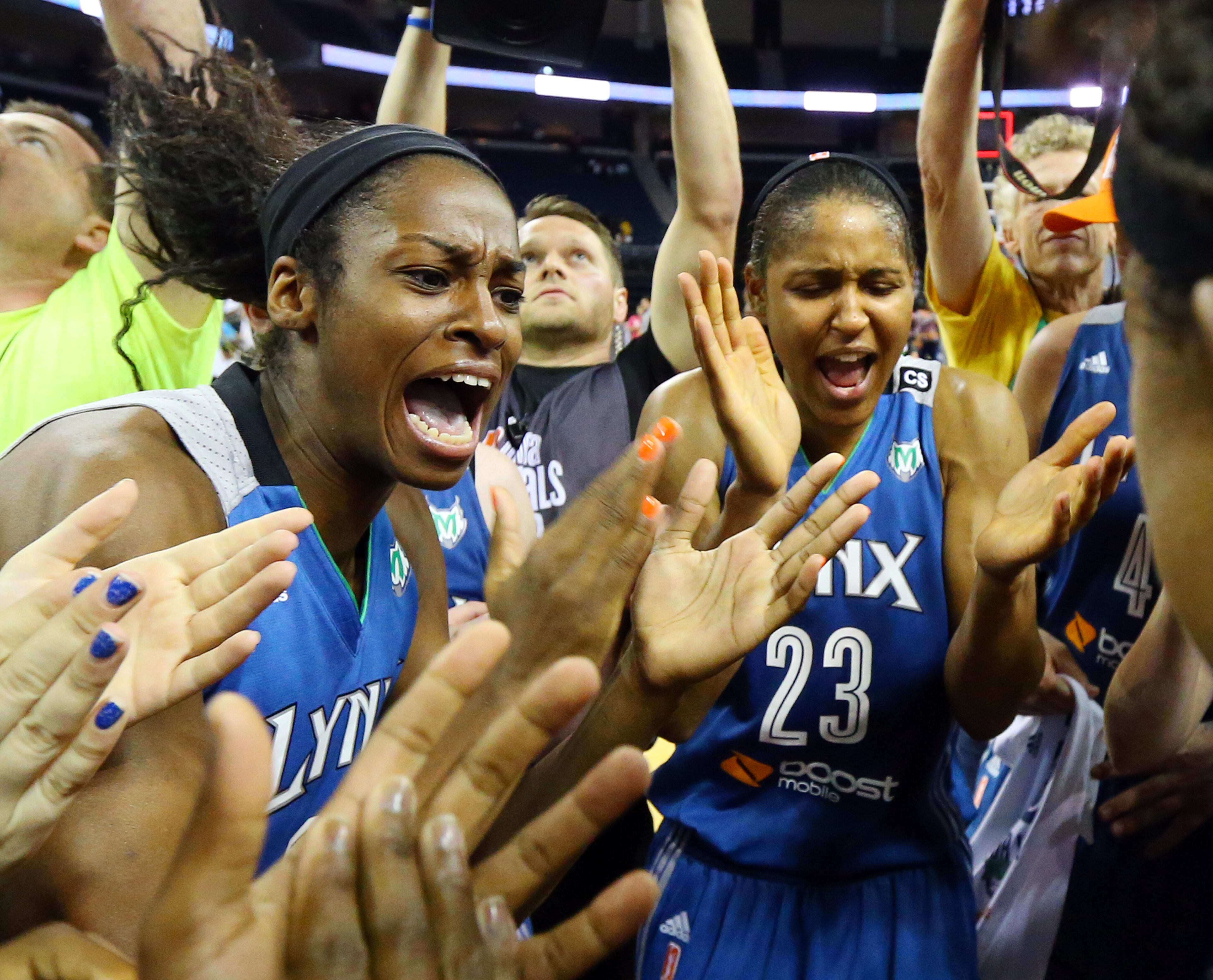 Lynx players Devereaux Peters (left) and Maya Moore celebrate with teammates defeating the Dream 86-77 to win the WNBA Championship on Thursday, Oct. 10, 2013, in Duluth.