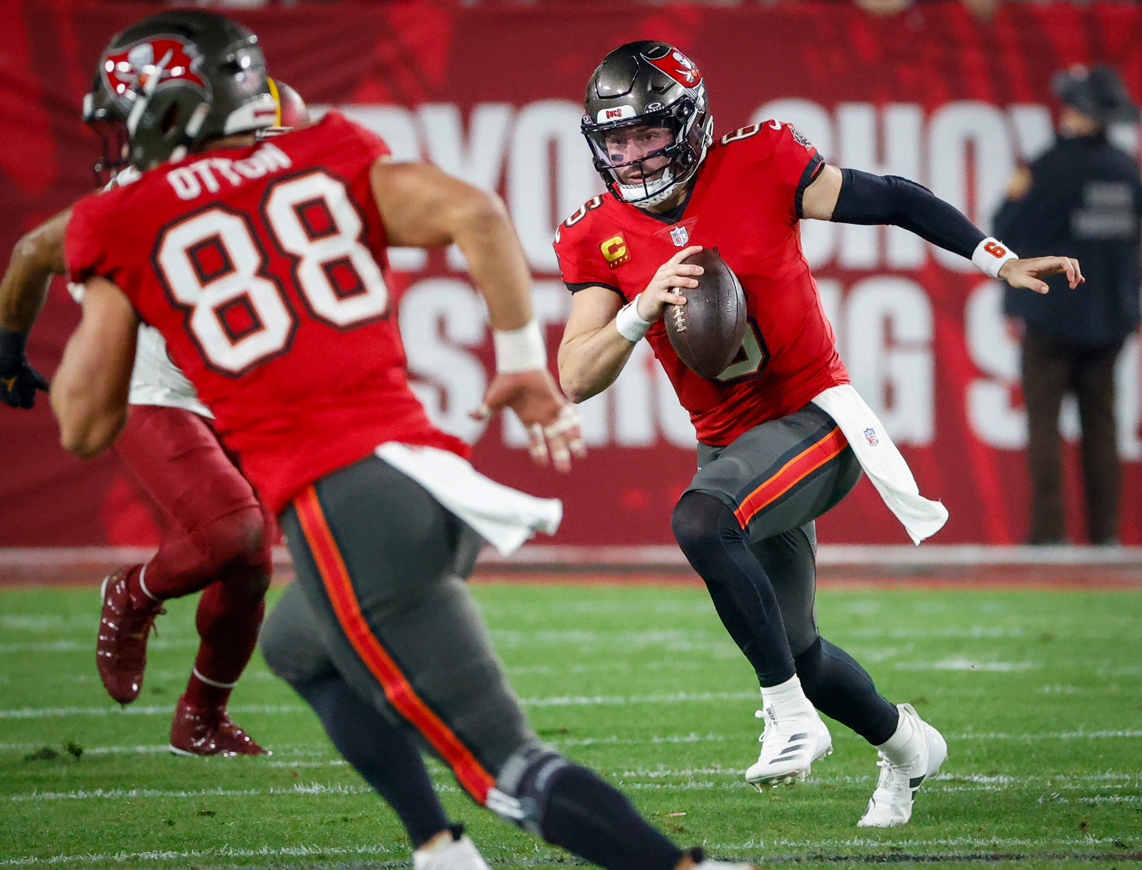 Tampa Bay Buccaneers quarterback Baker Mayfield, right, runs the ball during the first half against the Washington Commanders Sunday, Jan. 12, 2025, at Raymond James Stadium in Tampa, Florida. (Jefferree Woo/Tampa Bay Times/TNS)