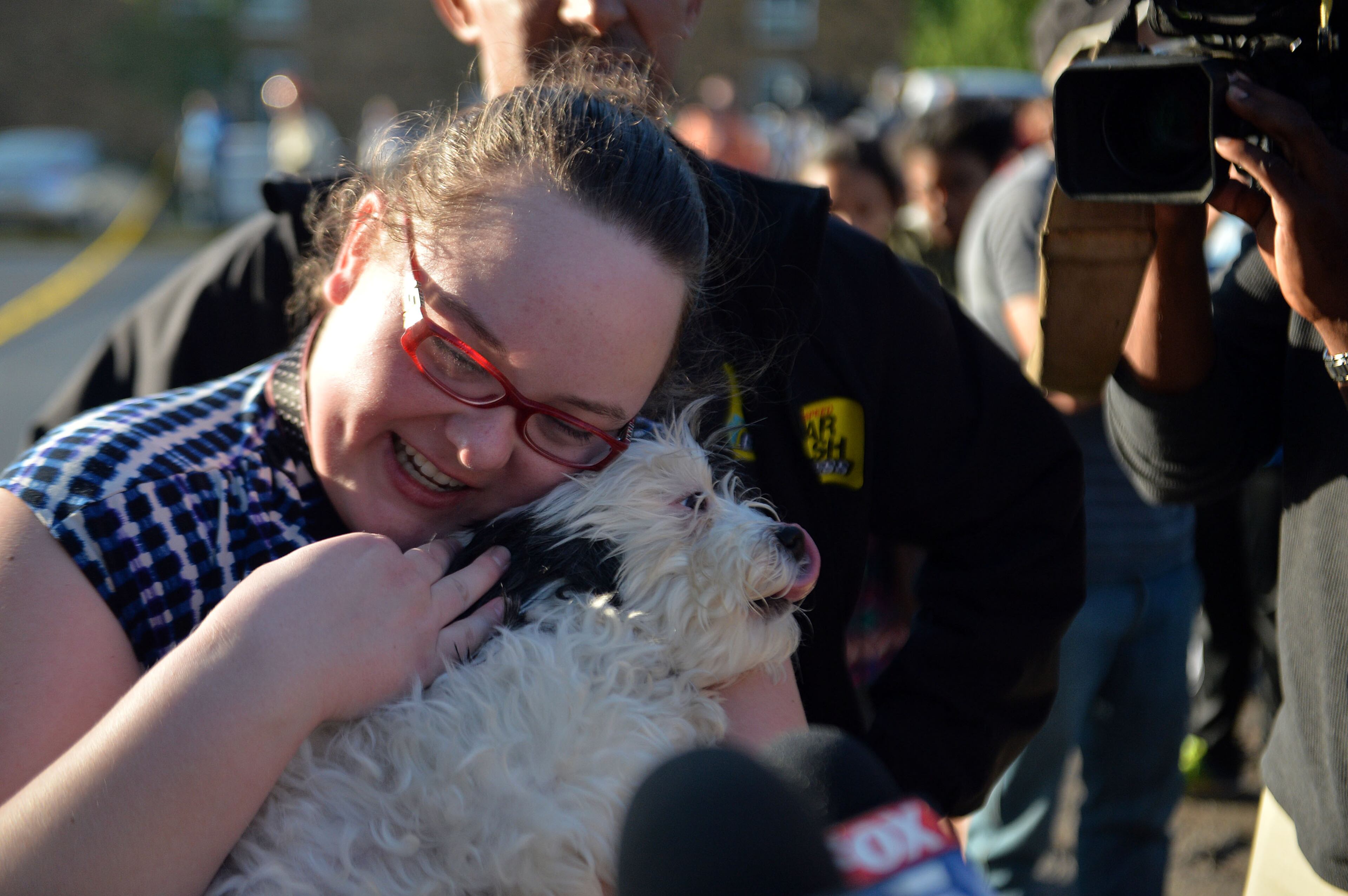 Atlanta resident Caitlin Strischek reacts as her dog, Marley, is brought out of the fire scene at the apartment complex at 1413 Druid Valley Road off Briarcliff Road on Friday May 1, 2015. KENT D. JOHNSON /KDJOHNSON@AJC.COM