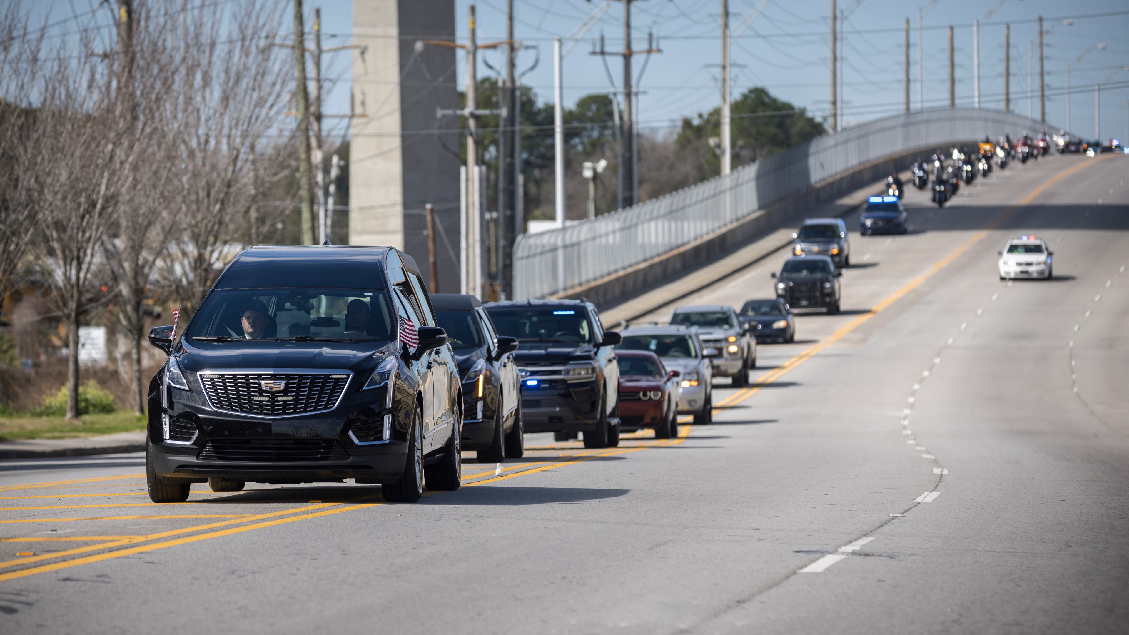 The hearse carrying remains of U.S. Army Reservist Sgt. Breonna Moffett nears downtown during a motorcade procession carrying her back home, Thursday, Feb. 15, 2024, Savannah, Ga.. (AJC Photo/Stephen B. Morton)