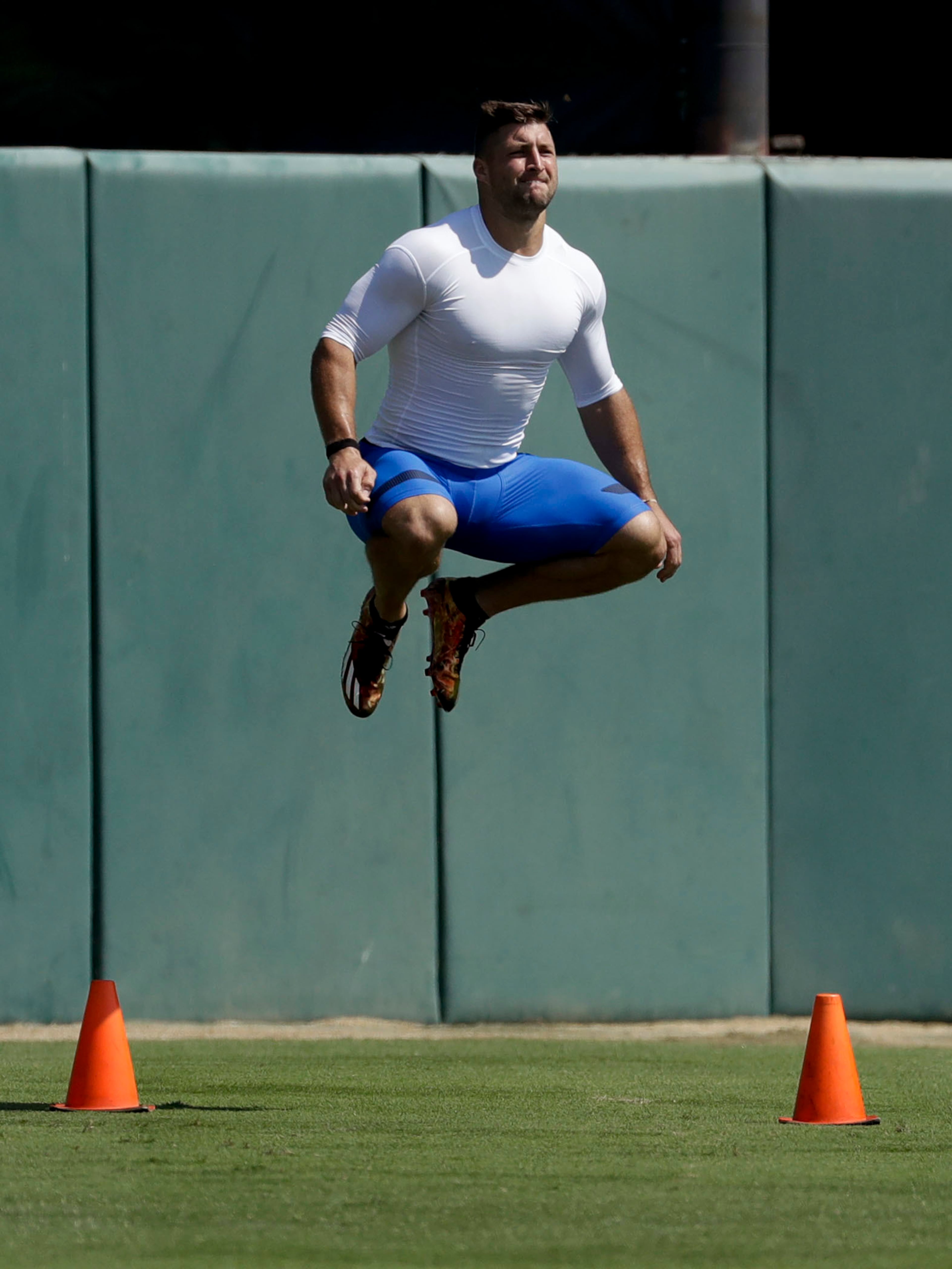 Former NFL quarterback, Tim Tebow warms up at the start of a 60-yard run for baseball scouts and the media during a showcase on the campus of the University of Southern California, Tuesday, Aug. 30, 2016 in Los Angeles. The Heisman Trophy winner works out for a big gathering of scouts on USC's campus in an attempt to start a career in a sport he hasn't played regularly since high school. (AP Photo/Chris Carlson)