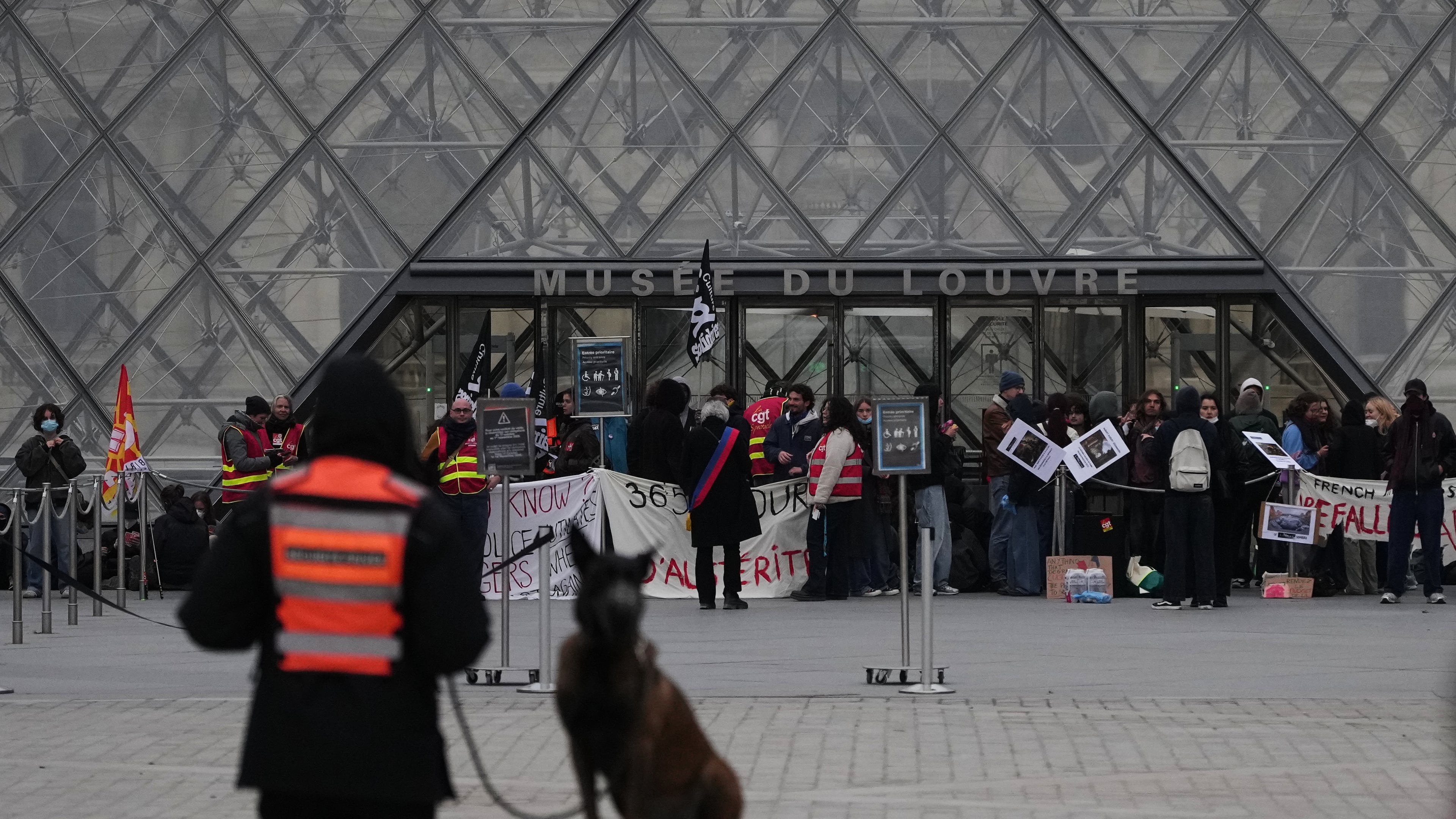 Workers block the entrance of the Louvre museum during a protests against rising living costs, in Paris, Monday, Oct. 19, 2026. (AP Photo/Christophe Ena)