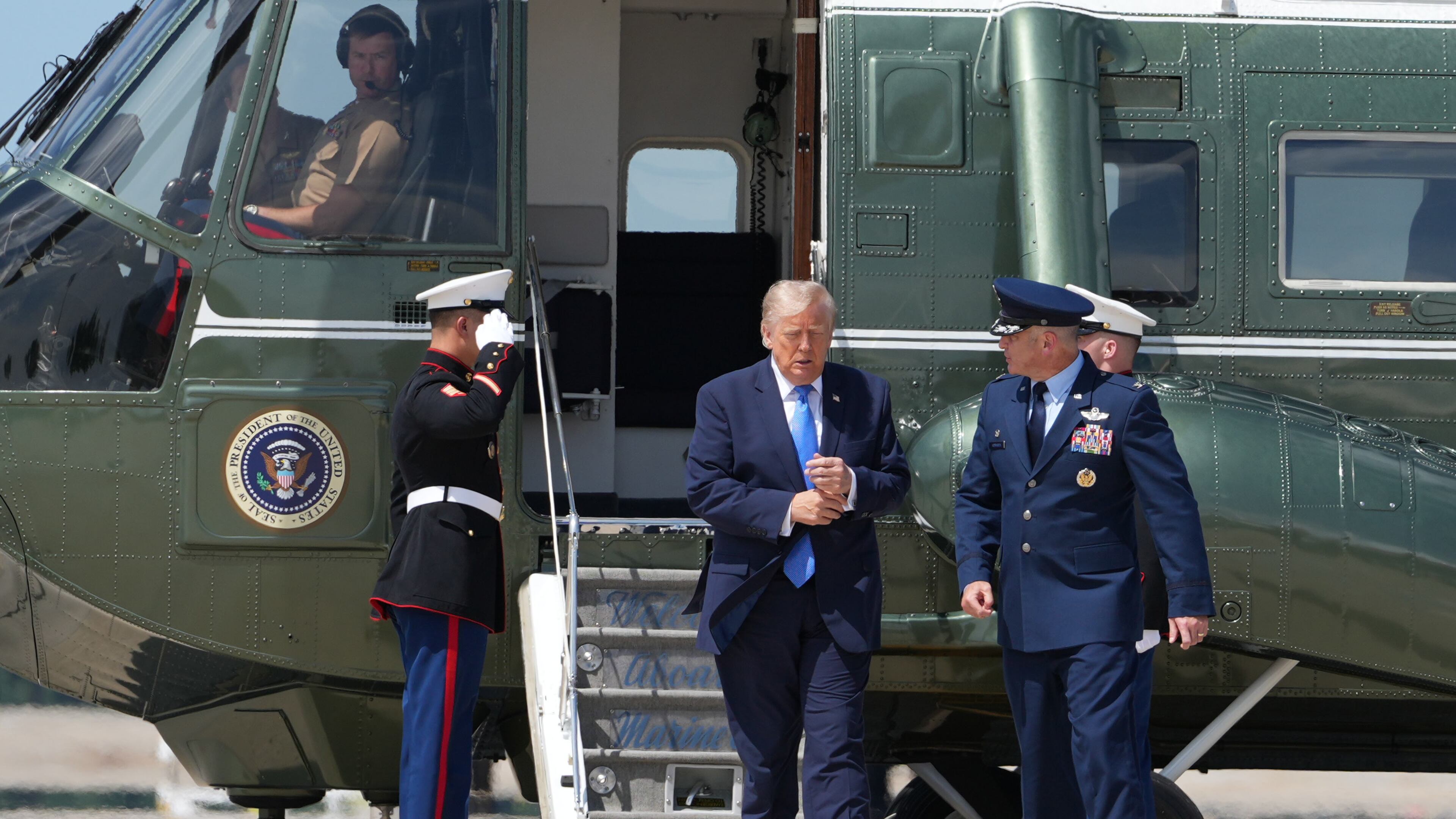 President Donald Trump walks from Marine One with Air Force Col. Christopher M. Robinson, commander of the 89th Airlift Wing, to board Air Force One, Tuesday, Aug. 4, 2026, at Joint Base Andrews, Md. (AP Photo/Mark Schiefelbein)