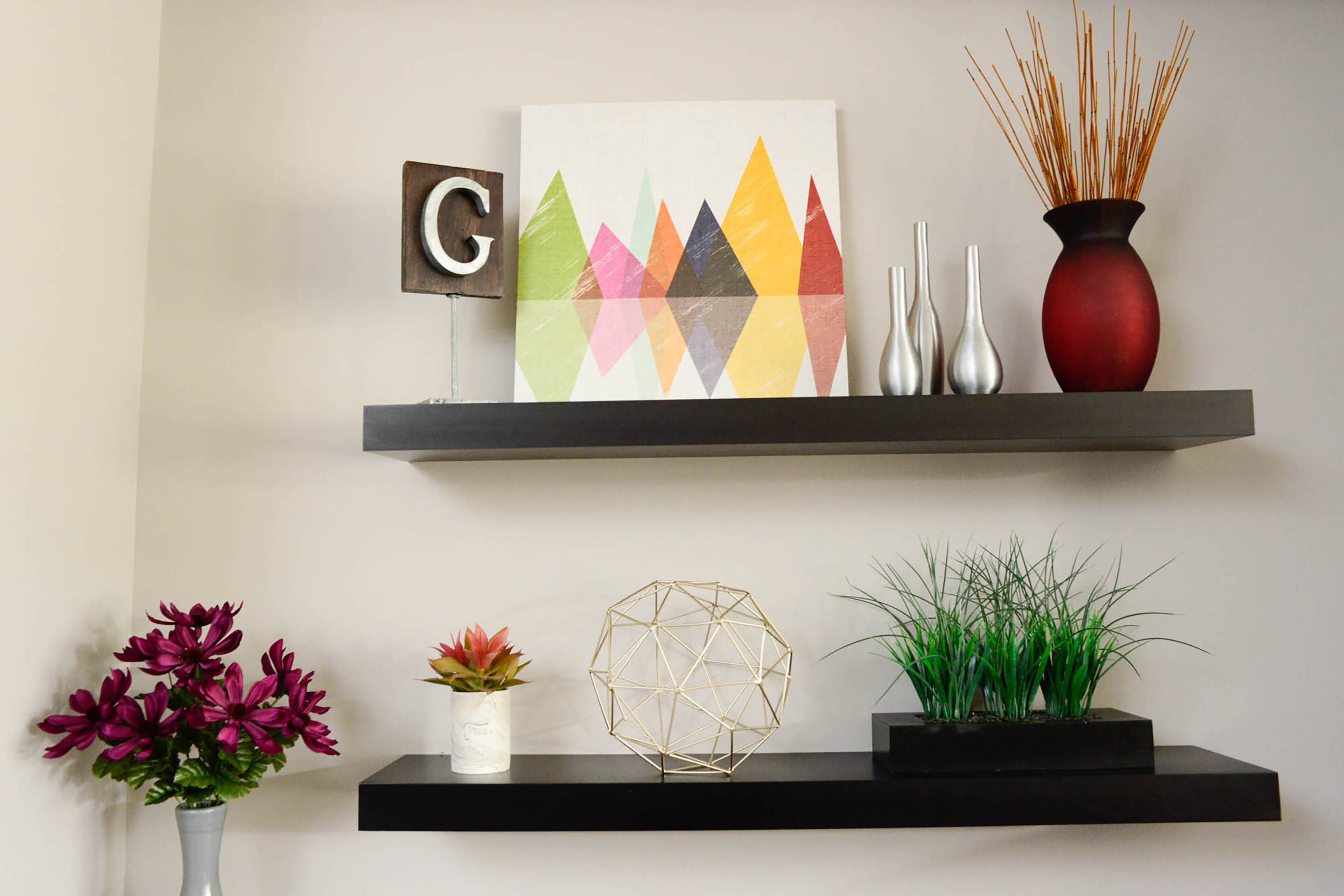 The colors of the diamonds within the artwork coordinate with the plants and flowers on custom shelves.