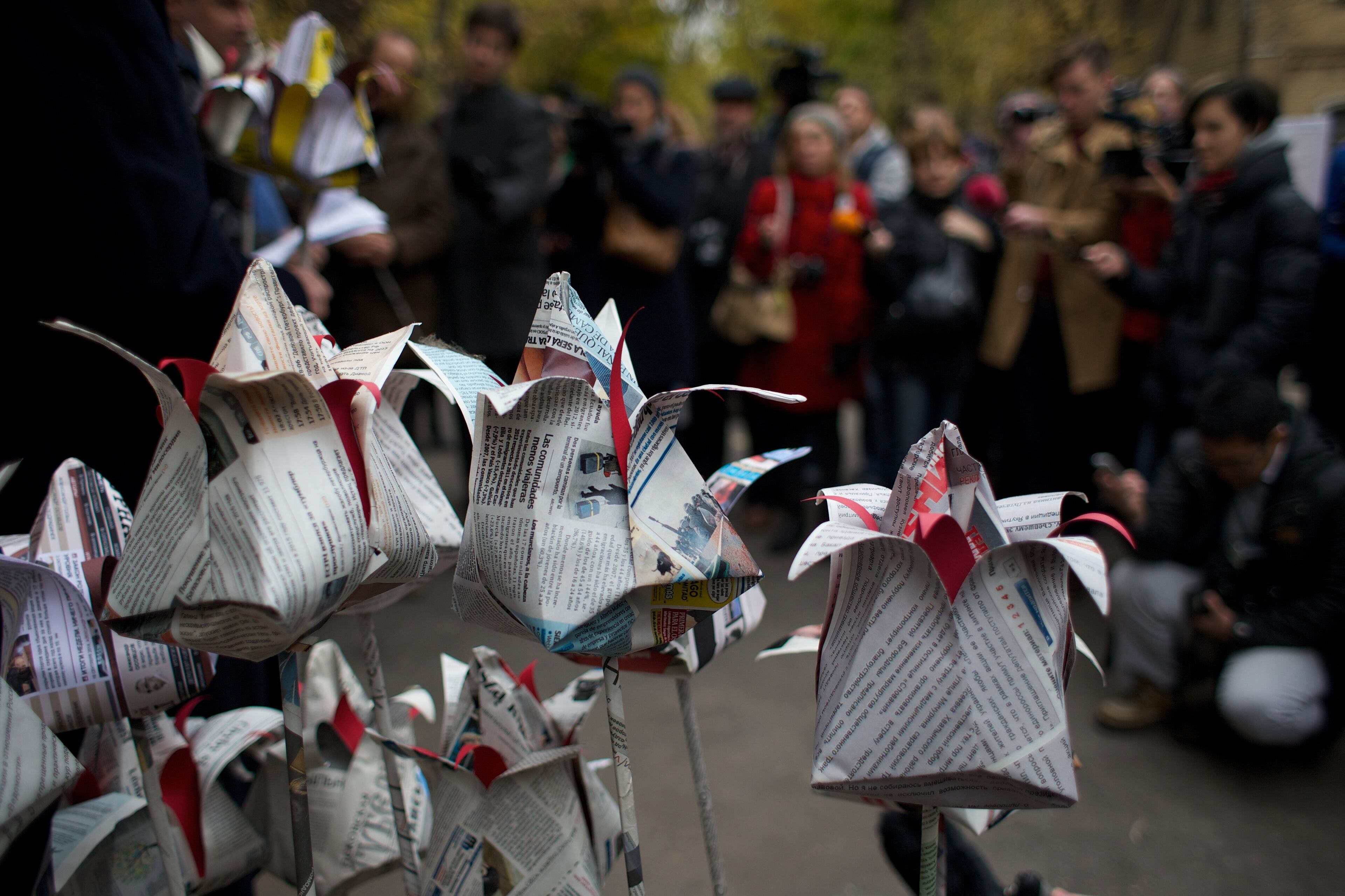 People lay flowers made from newspapers to pay respect to Anna Politkovskaya, journalist of Novaya Gazeta, outside Novaya Gazeta head office in Moscow, Russia, Tuesday, Oct. 7, 2014. Tuesday marks 8 years since Politkovskaya was killed.(AP Photo/Ivan Sekretarev)