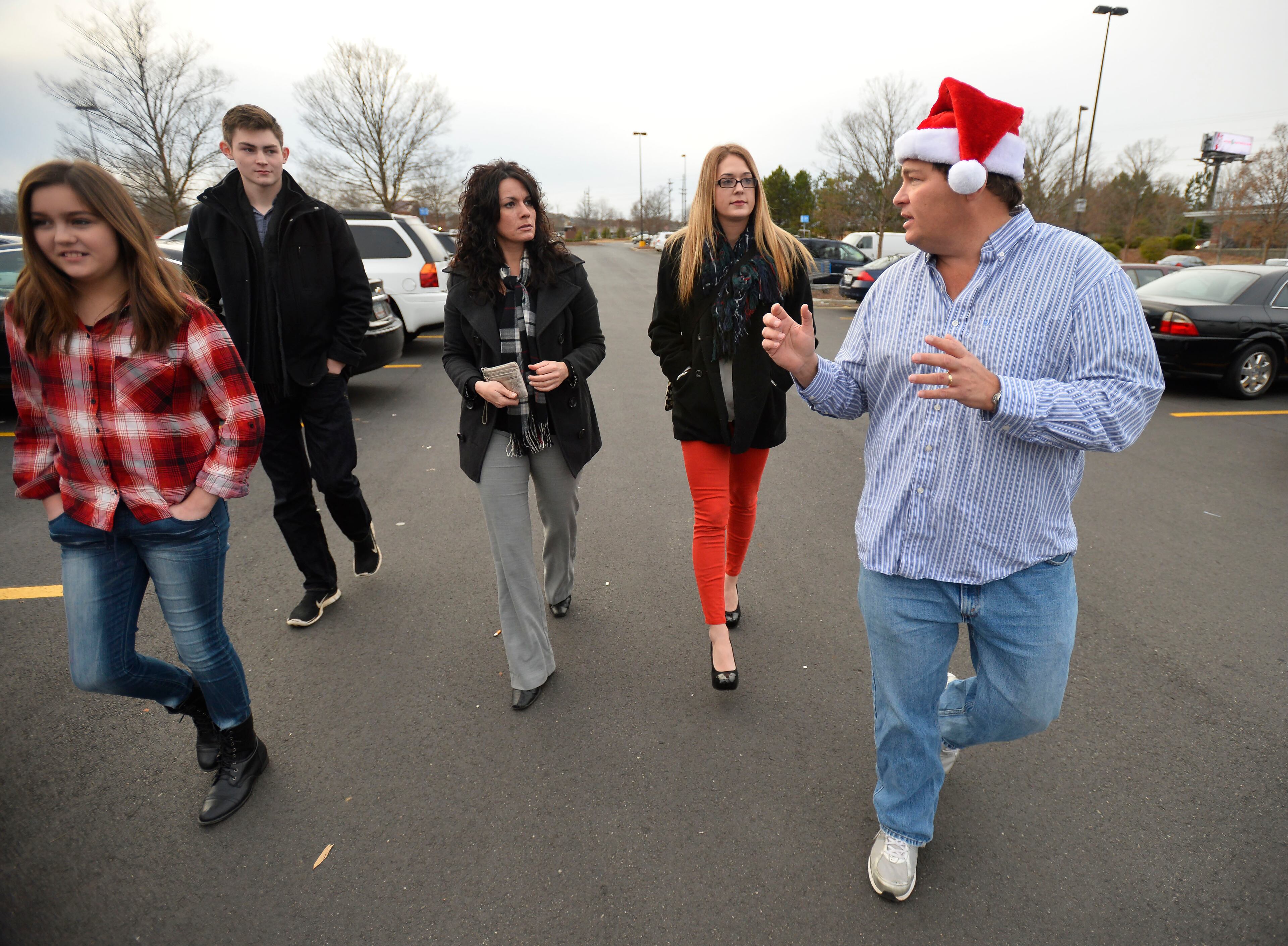 Frank Duffy, right, prepares to shop for more than 200 toys with Duffy Real Estate employees Kelli Parker, Nicole Tatusko and his children Sean and Ryan, left, during a toy drive where he matched 275 toys donated by clients and employees and delivered them to the Toys for Tots charity on Friday, Dec. 19, 2014, in Alpharetta, Ga. "We did it as a family last year and having the staff participate makes it even more fun," Duffy said. (AP Photo/David Tulis)Atlanta Holiday Guide 2015: Holiday lights and events