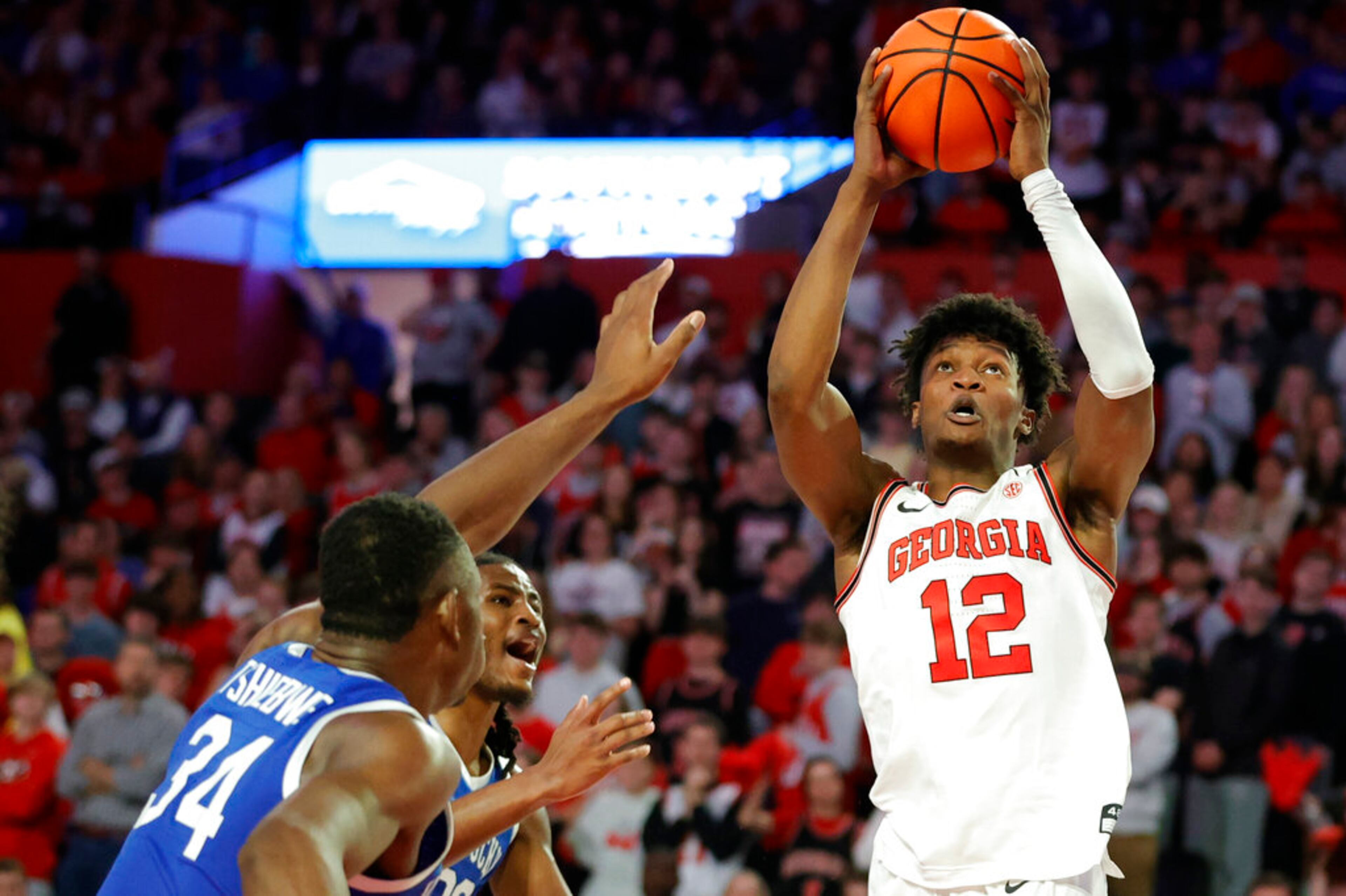 Georgia forward Matthew-Alexander Moncrieffe, right, shoots over Kentucky's Oscar Tshiebwe, left, and Cason Wallace, center, during the second half of an NCAA college basketball game, Saturday, Feb. 11, 2023, in Athens, Ga. (AP Photo/Alex Slitz)