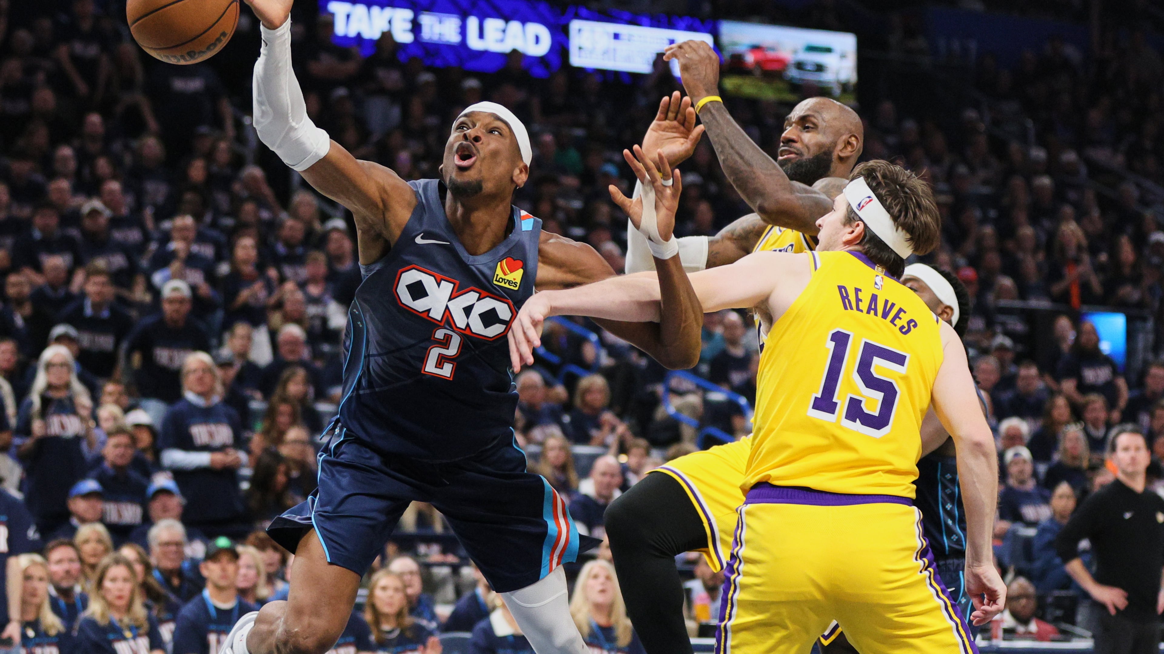 Oklahoma City Thunder's Shai Gilgeous-Alexander (2) is fouled driving to the basket by Los Angeles Lakers' Austin Reaves (15) as LeBron James, right rear, follows behind on the play in the second half of Game 2 in a second-round NBA basketball playoffs series Thursday, May 7, 2026, in Oklahoma City. (AP Photo/Nate Billings)