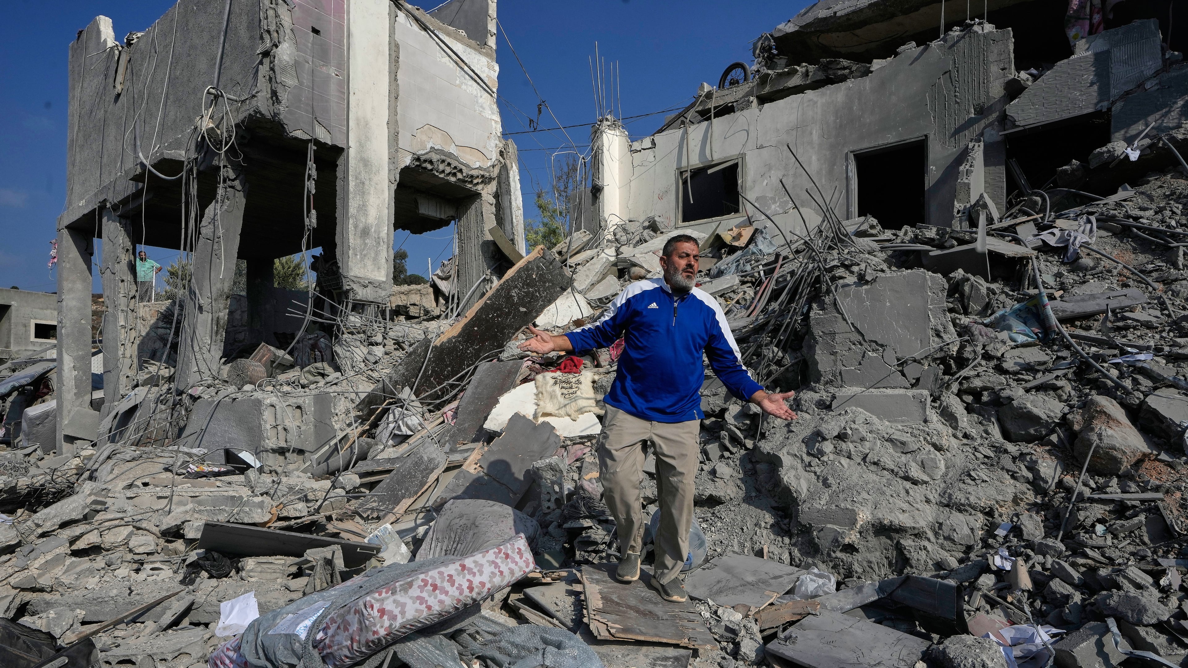 A man reacts on the rubble of a destroyed home that was hit by an Israeli airstrike in Ansar village, southern Lebanon, Saturday, Aug. 15, 2026. (AP Photo/Mohammed Zaatari)