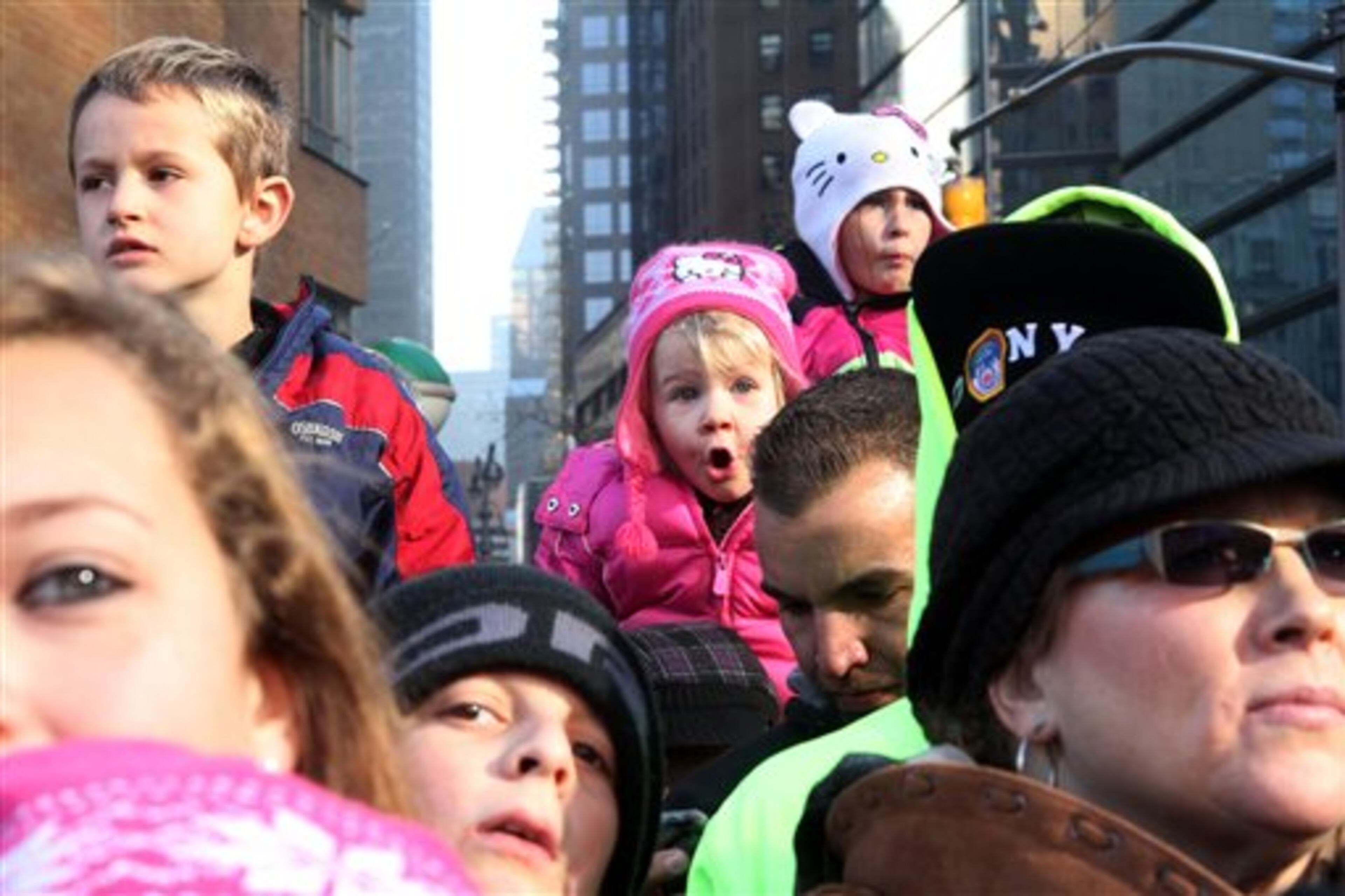 Reagon Long, 3, from Oxford, N.Y, background center, watches the 86th Annual Macy's Thanksgiving Day Parade Thursday Nov. 22, 2012, in New York. The annual Macy's Thanksgiving Day Parade put a festive mood in the air in a city still coping with the aftermath of Superstorm Sandy. (AP Photo/Tina Fineberg)