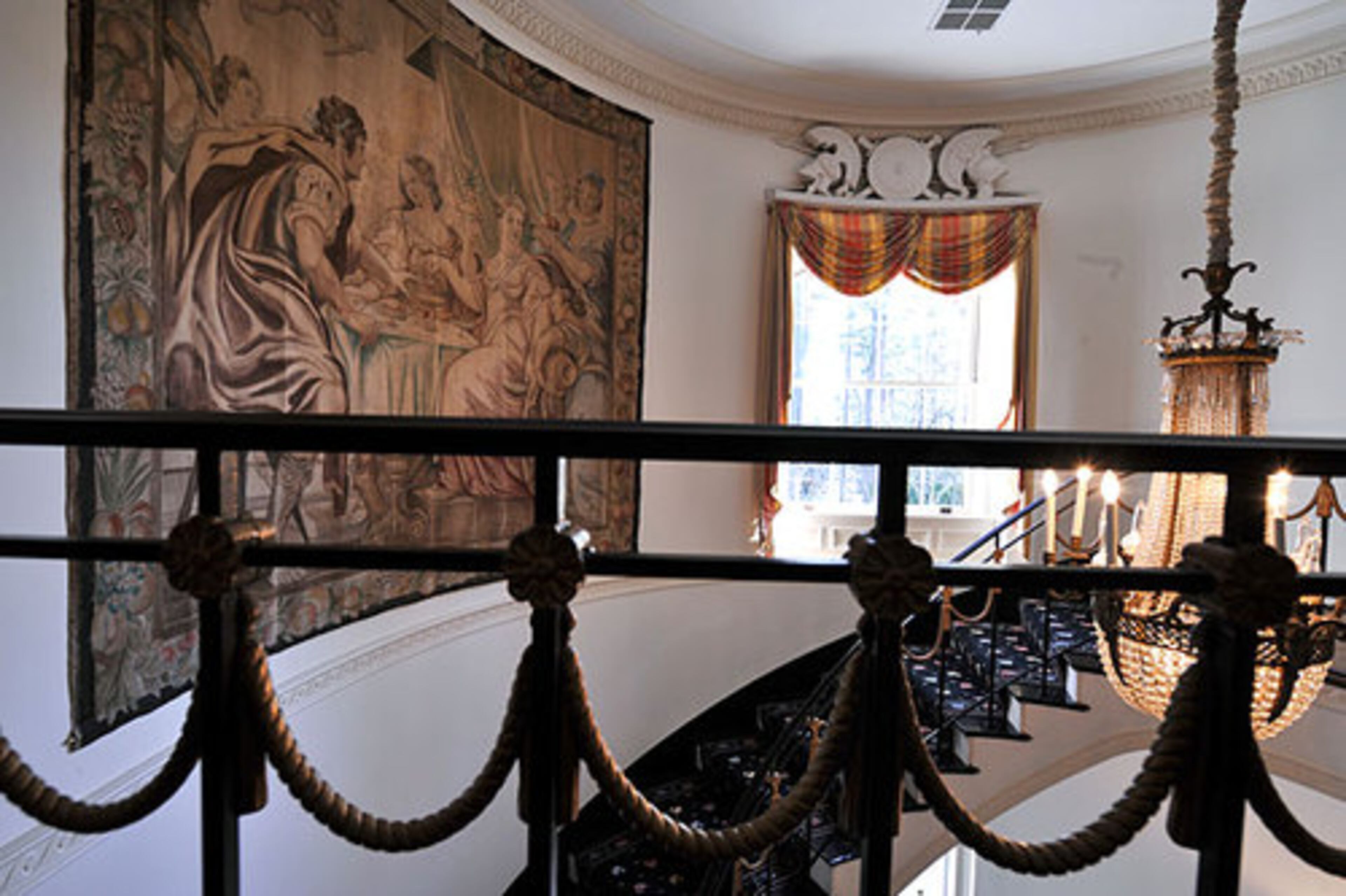 The railing on the spiral staircase is made of painted iron that looks like rope.