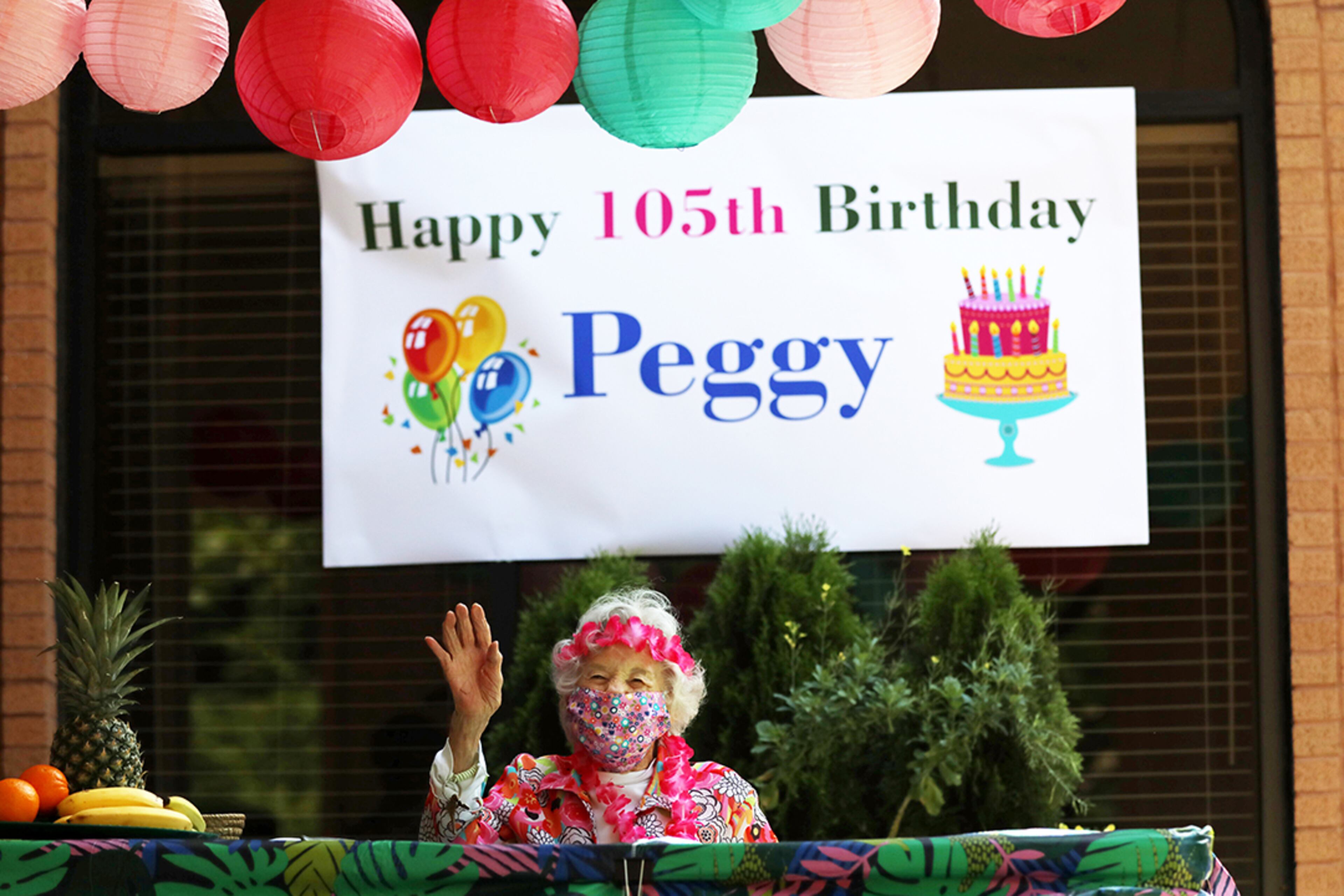 Peggy Cobb waves to friends and family members who gathered outside to celebrate her 105th birthday. Staff and residents pf the Hammond Glen Retirement Community in Sandy Springs celebrated her birthday a day early on Friday, May 22, 2020. (Photo: Miguel Martinez for The Atlanta Journal-Constitution)