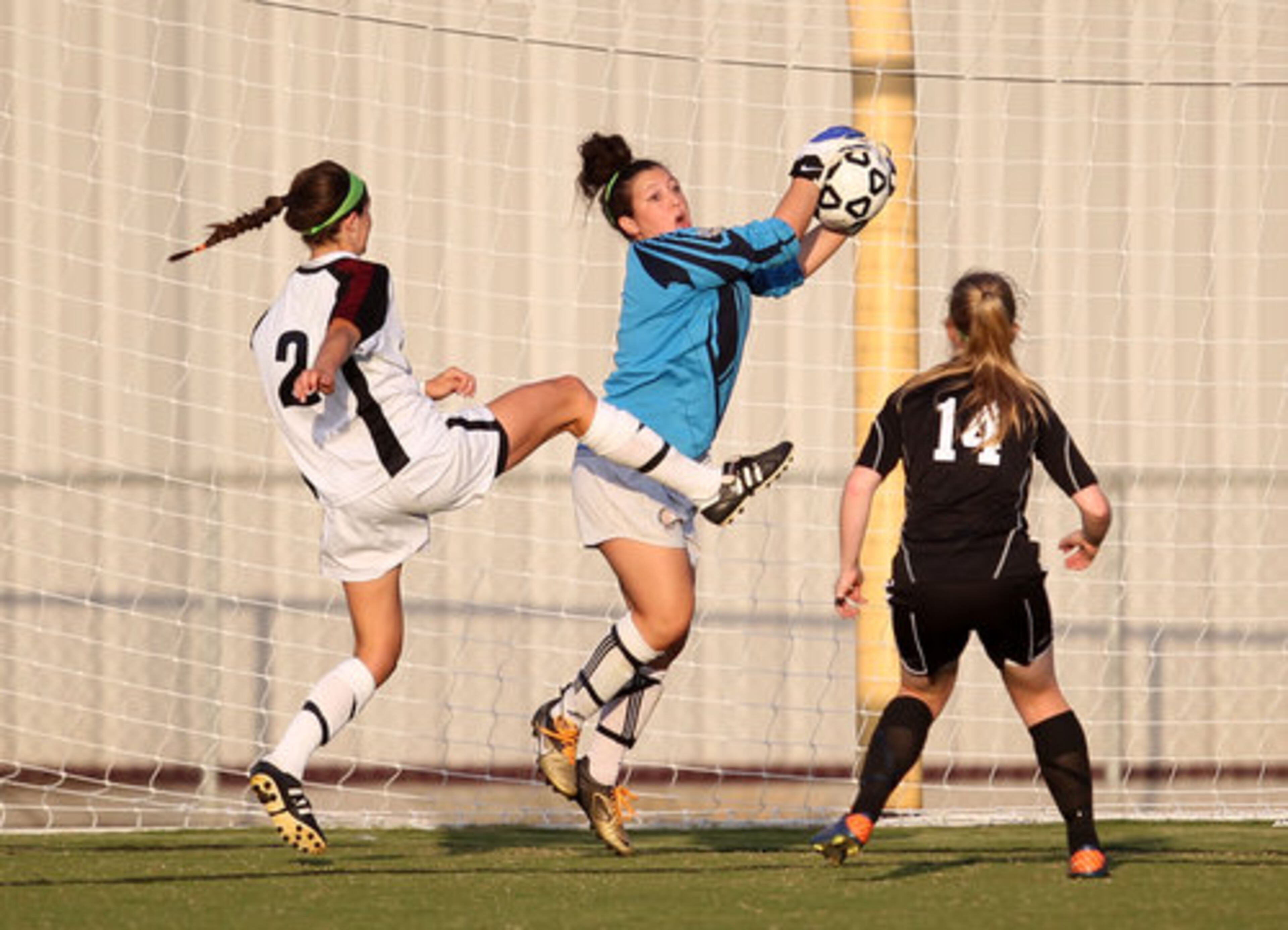 McIntosh goalkeeper Kaitlin Deitrick, center, grabs a deflected shot as Whitewater's Abbey Reddig (2) goes for the ball as McIntosh's Kaitlyn McBride (14) is shown on the play in the first half of the Class AAAA girls soccer state championship game at Whitewater High School Saturday afternoon in Fayetteville, Ga., May 19, 2012. Goalkeeper Deitrick was kicked on the play by Reddig but returned to the game in the second half.
