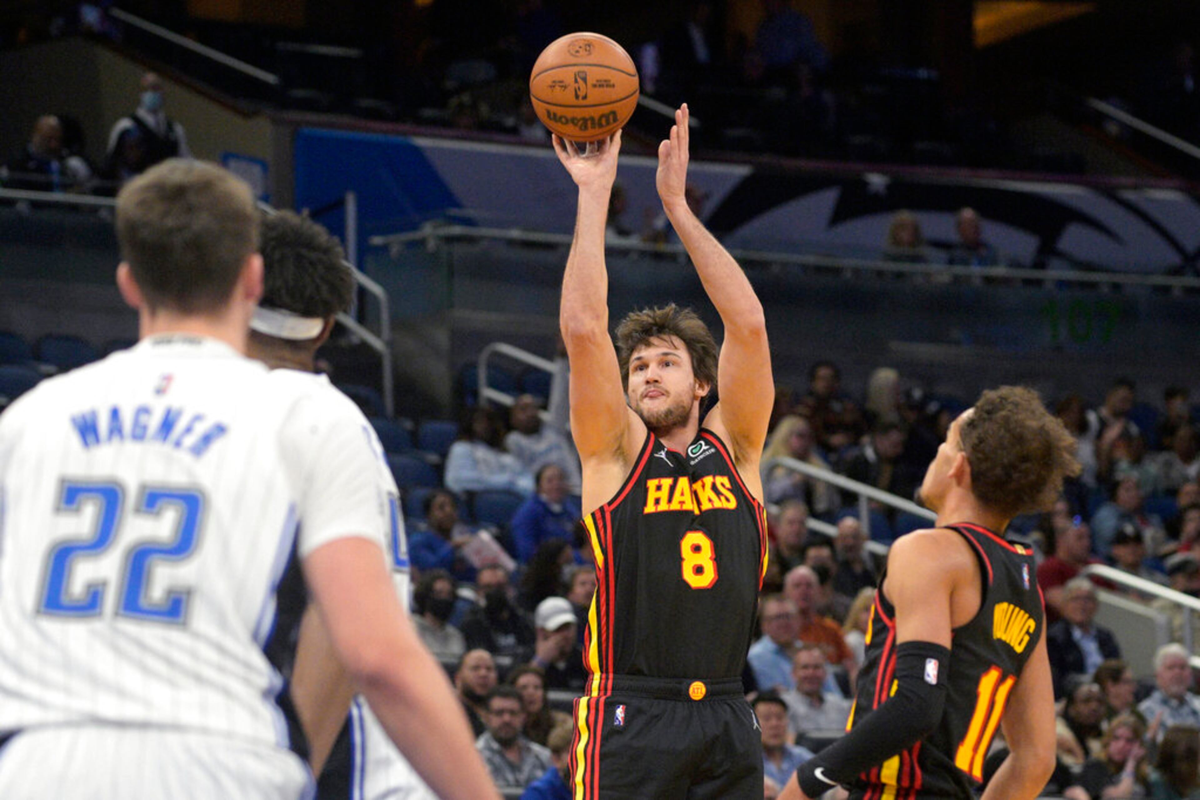 Atlanta Hawks forward Danilo Gallinari (8) shoots a 3-pointer as teammate Trae Young (11) and Orlando Magic forward Franz Wagner (22) watch during the first half of an NBA basketball game Wednesday, Feb. 16, 2022, in Orlando, Fla. (AP Photo/Phelan M. Ebenhack)