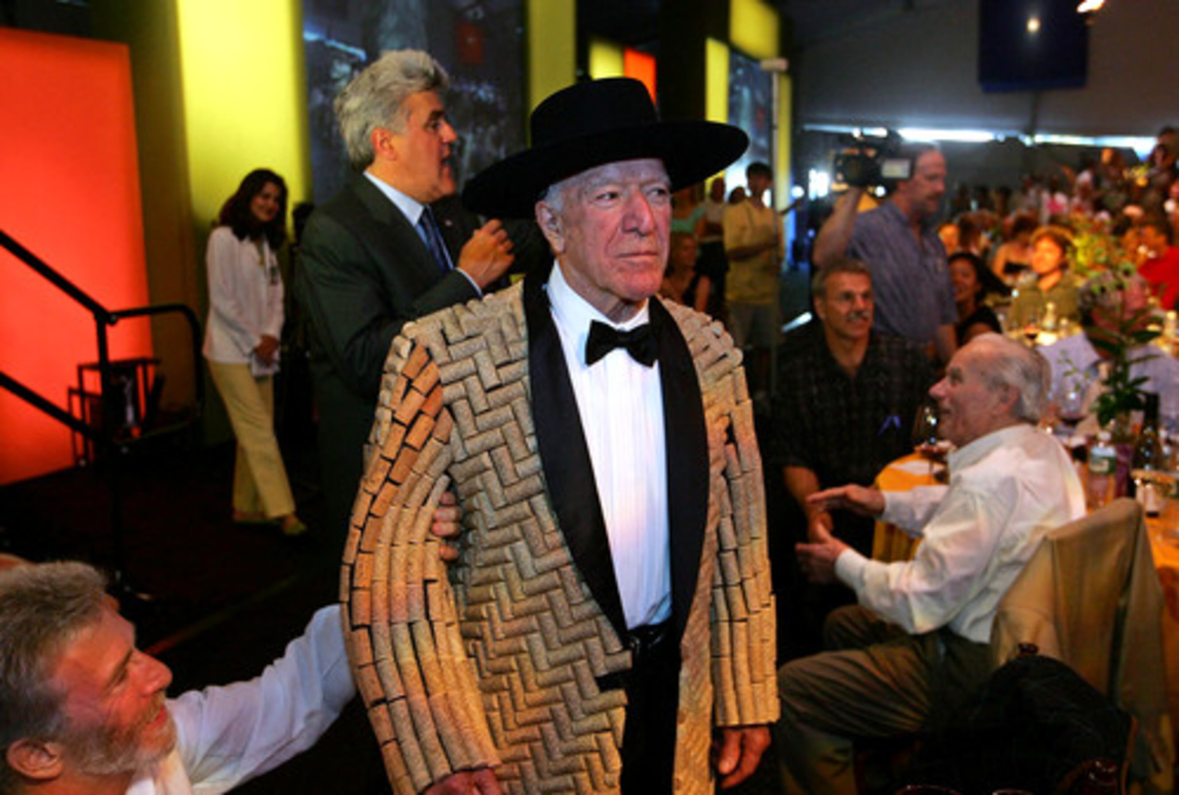 Robert Mondavi models a jacket made of corks as Jay Leno, background, auctions it off during a live auction event at the Napa Valley wine auction in St. Helena, Calif., in 2005.