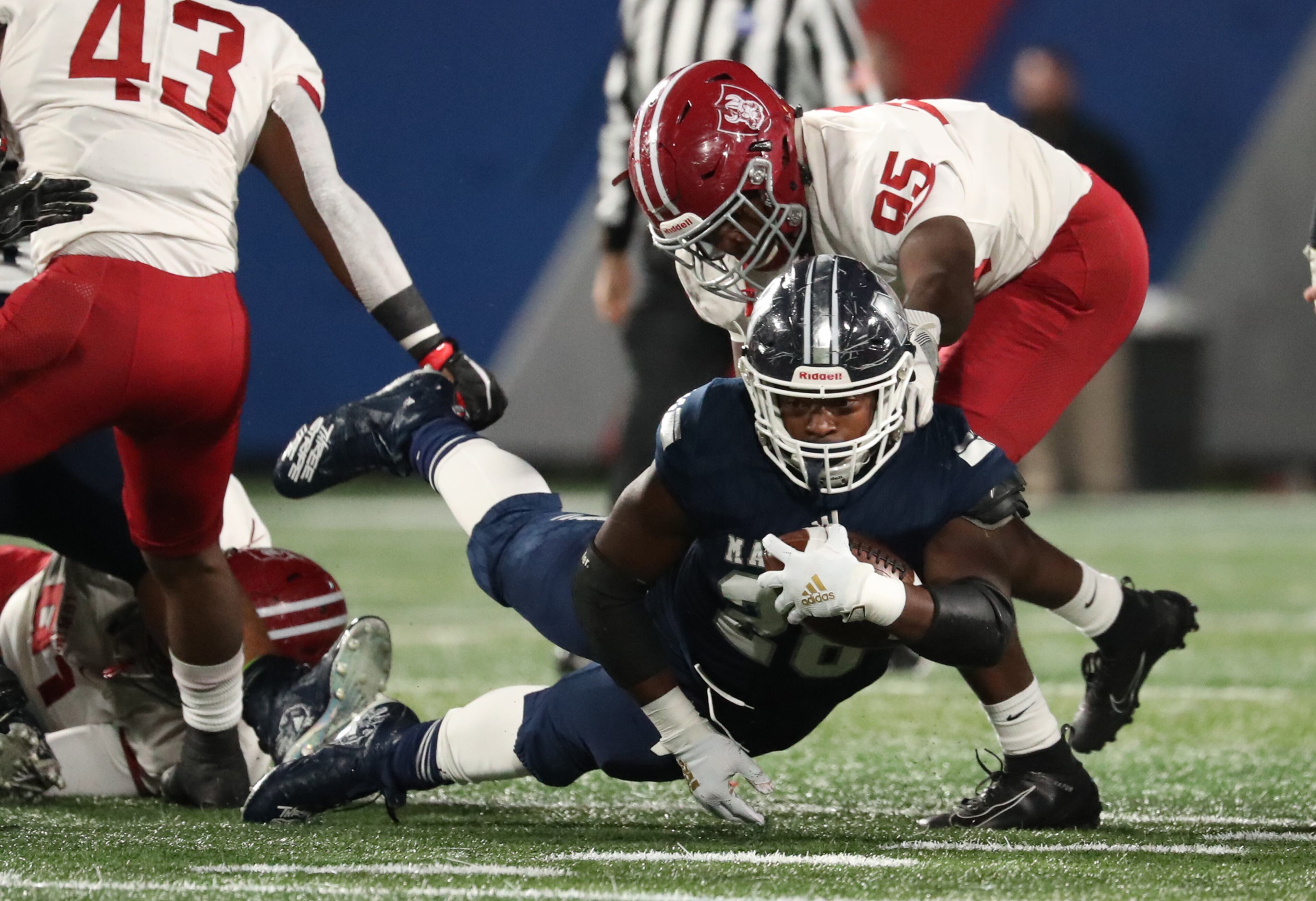 Marietta running back Kimani Vidal (28) dives for extra yards against Lowndes defensive lineman Thomas Davis (95) in the first half of the Class AAAAAAA high school football state title game at Georgia State Stadium Saturday, December 14, 2019 in Atlanta. (JASON GETZ/SPECIAL TO THE AJC)