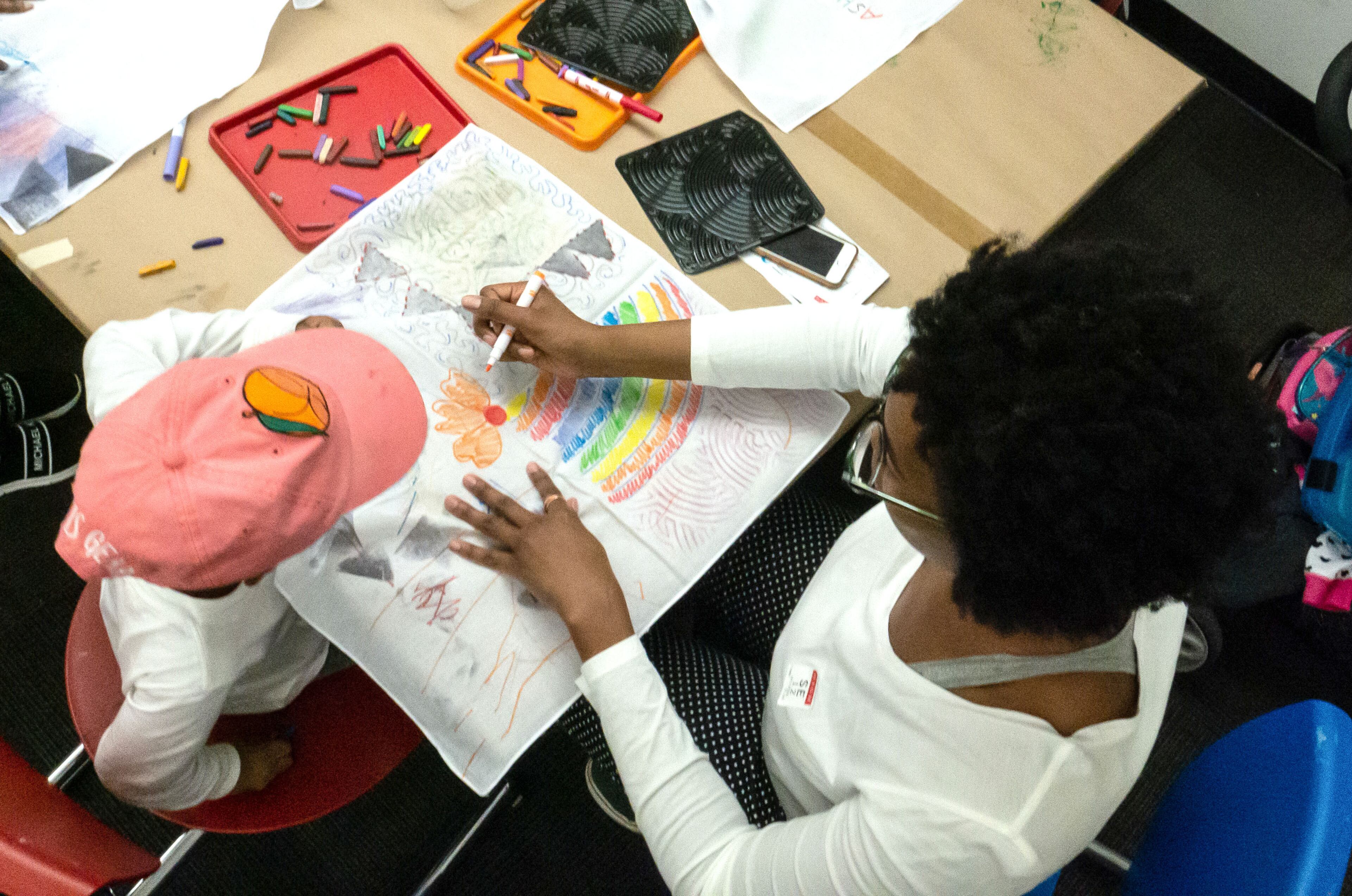 Kori Burrell helps her child Yuri color at the art-making workshop during the Woodruff Family Fun Fest at the Woodruff Arts Center in Atlanta on Sunday, January 12, 2020. STEVE SCHAEFER / SPECIAL TO THE AJC