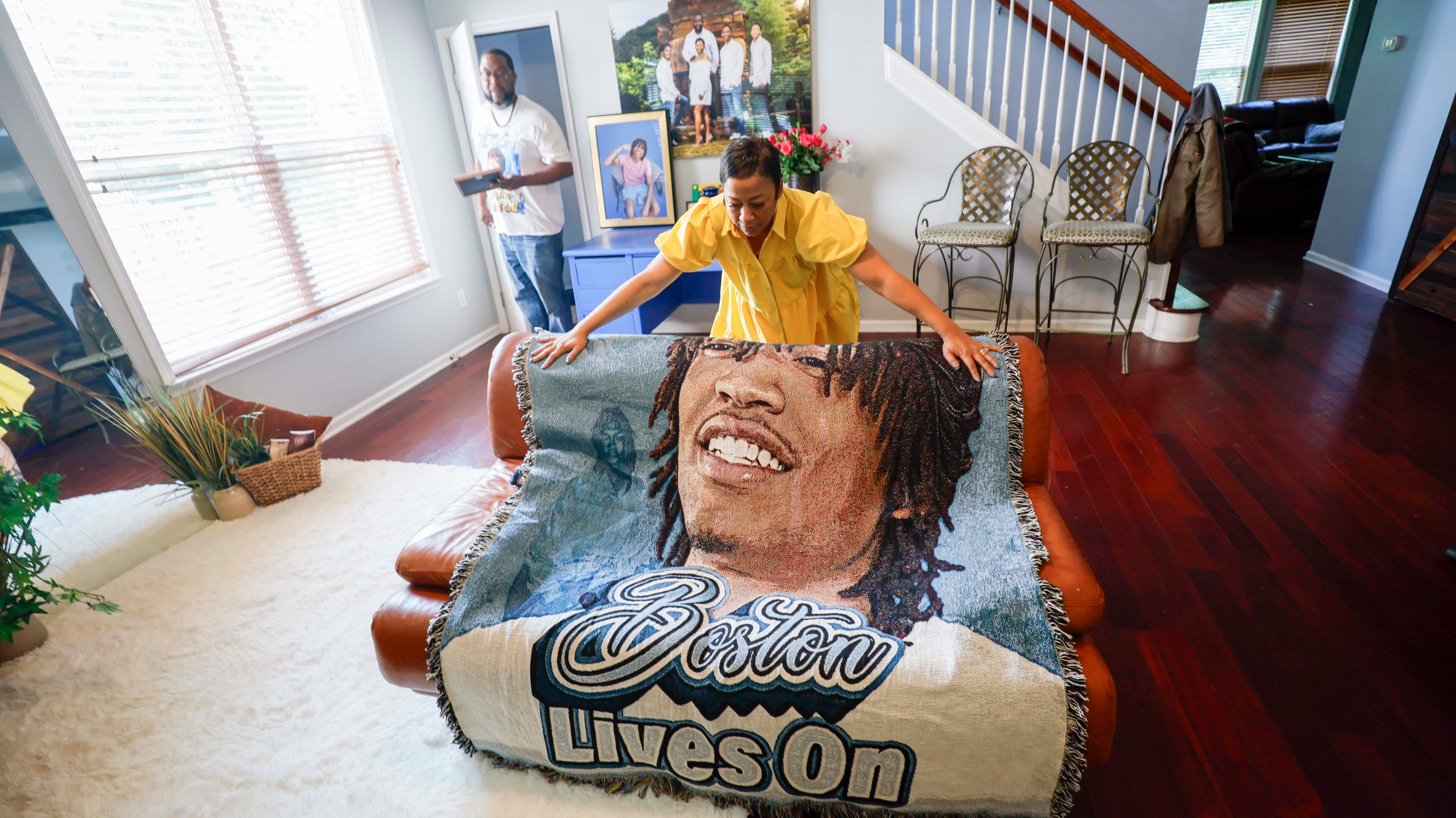 Terrica Thomas fixes a blanket featuring her 21-year-old son, Boston Thomas, which was gifted by a friend after his death. (Miguel Martinez/AJC)