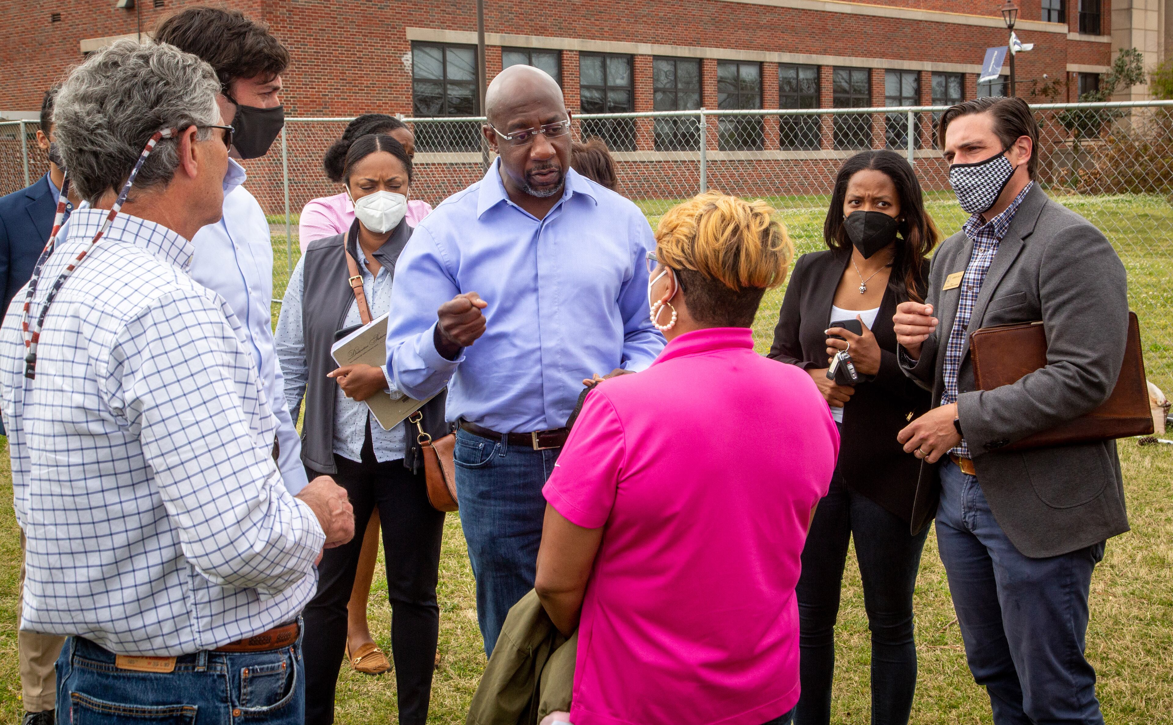 U.S. Sen. Raphael Warnock, D-Ga., (center) talks with community members after a press conference near Newnan High School on Saturday, April 17, 2021. (Photo: Steve Schaefer for The Atlanta Journal-Constitution)