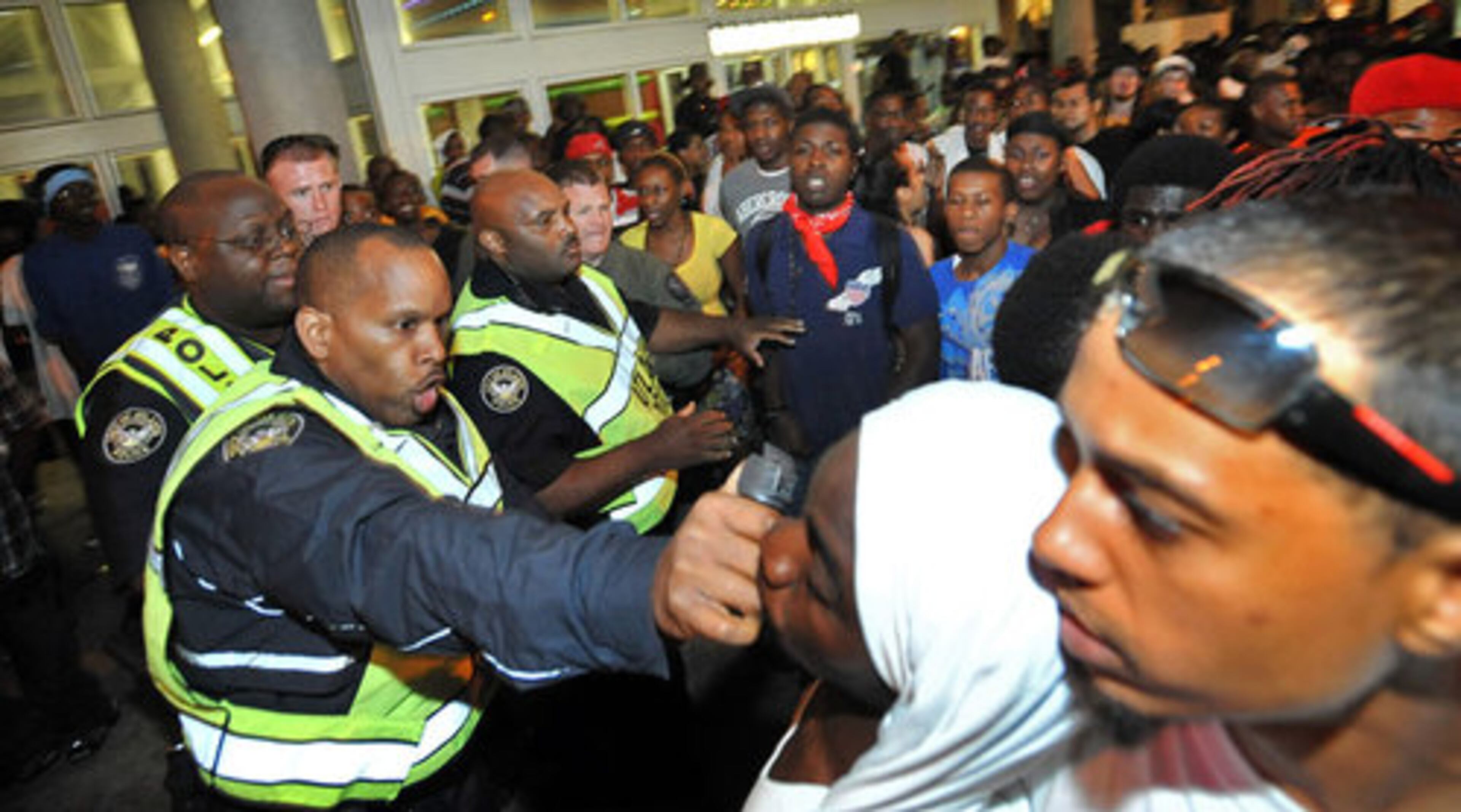 An Atlanta Police officer pushes a man as the officer tries to control the crowd late Saturday night at the Underground Atlanta.