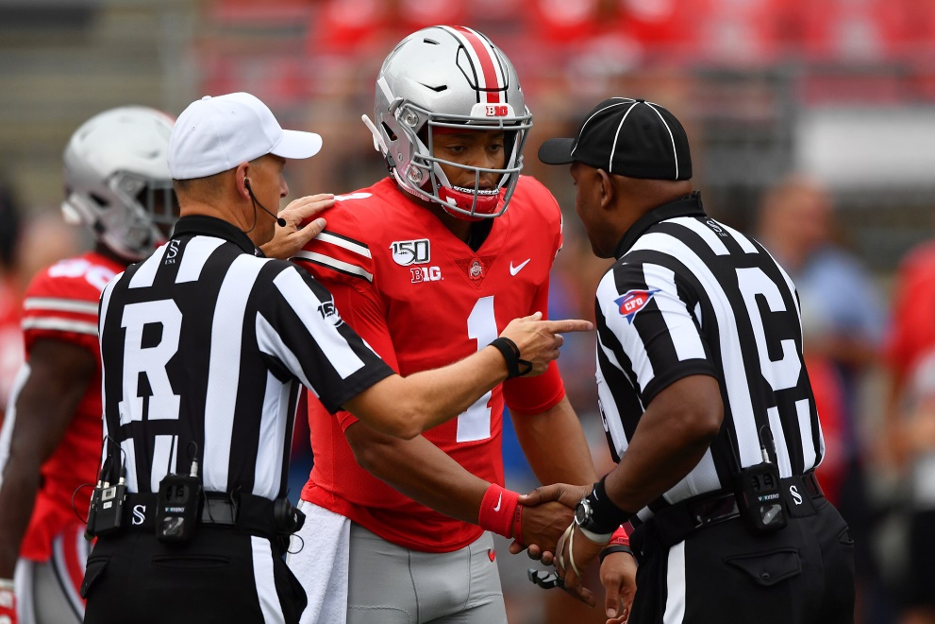 Justin Fields #1 of the Ohio State Buckeyes meets with officials before a game against the Florida Atlantic Owls at Ohio Stadium on August 31, 2019 in Columbus, Ohio. (Photo by Jamie Sabau/Getty Images)