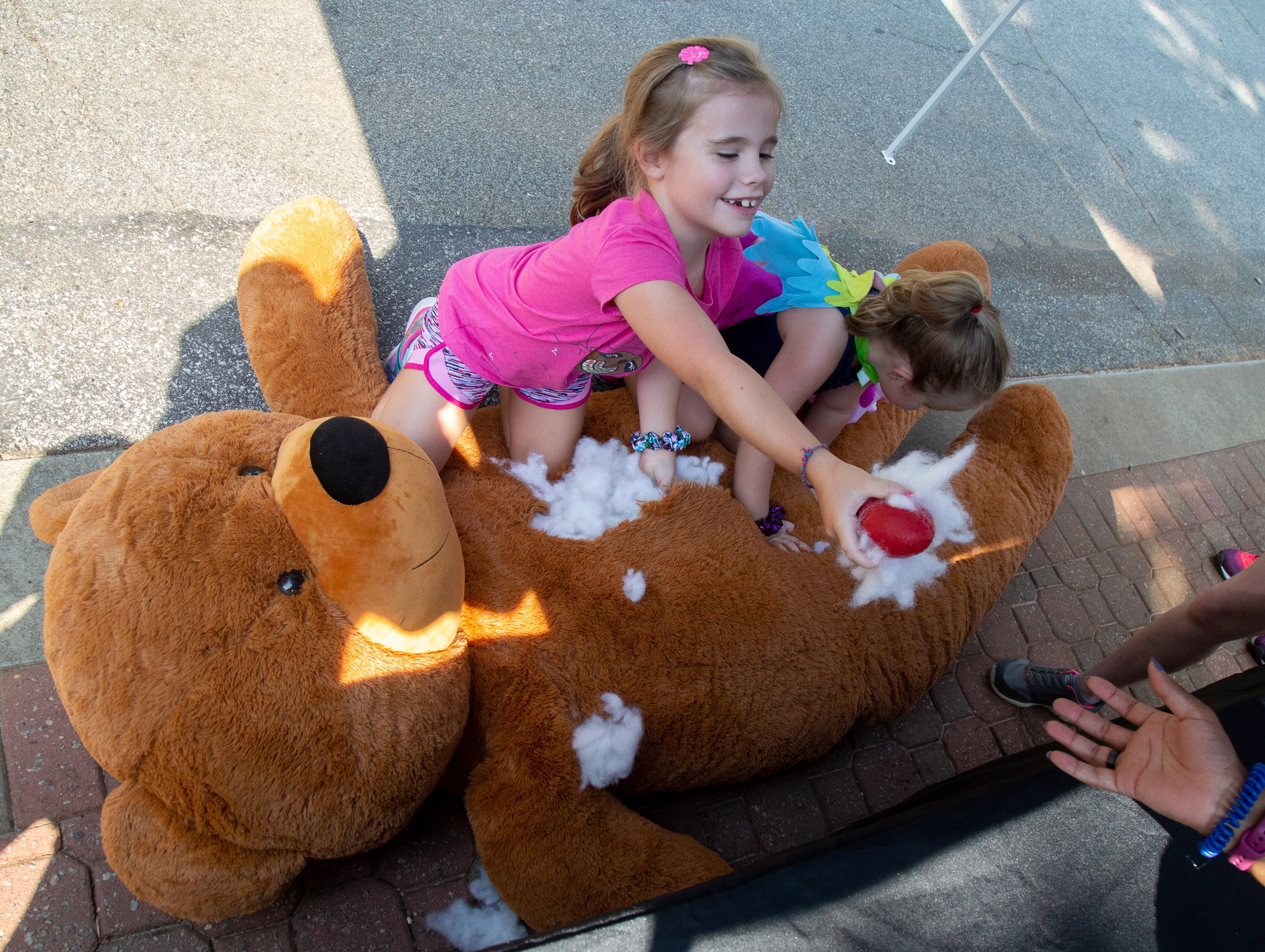 Madelyn Walker (L) and her sister Quinn find objects inside a giant stuffed bear during Play the Animal Way and Vulture Awareness Day at Zoo Atlanta on Saturday, September 7, 2019. STEVE SCHAEFER / SPECIAL TO THE AJC