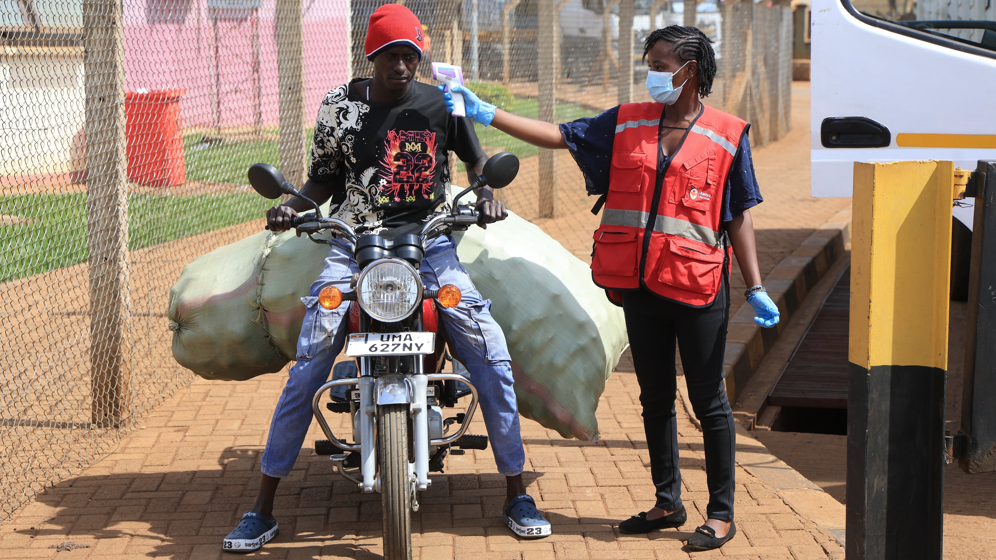A Kenyan health worker checks the temperatures of travelers crossing from Uganda to Kenya as part of measures to contain the spread of Ebola virus, in Busia, Kenya, Thursday, Oct. 15, 2026. (AP Photo/Andrew Kasuku)