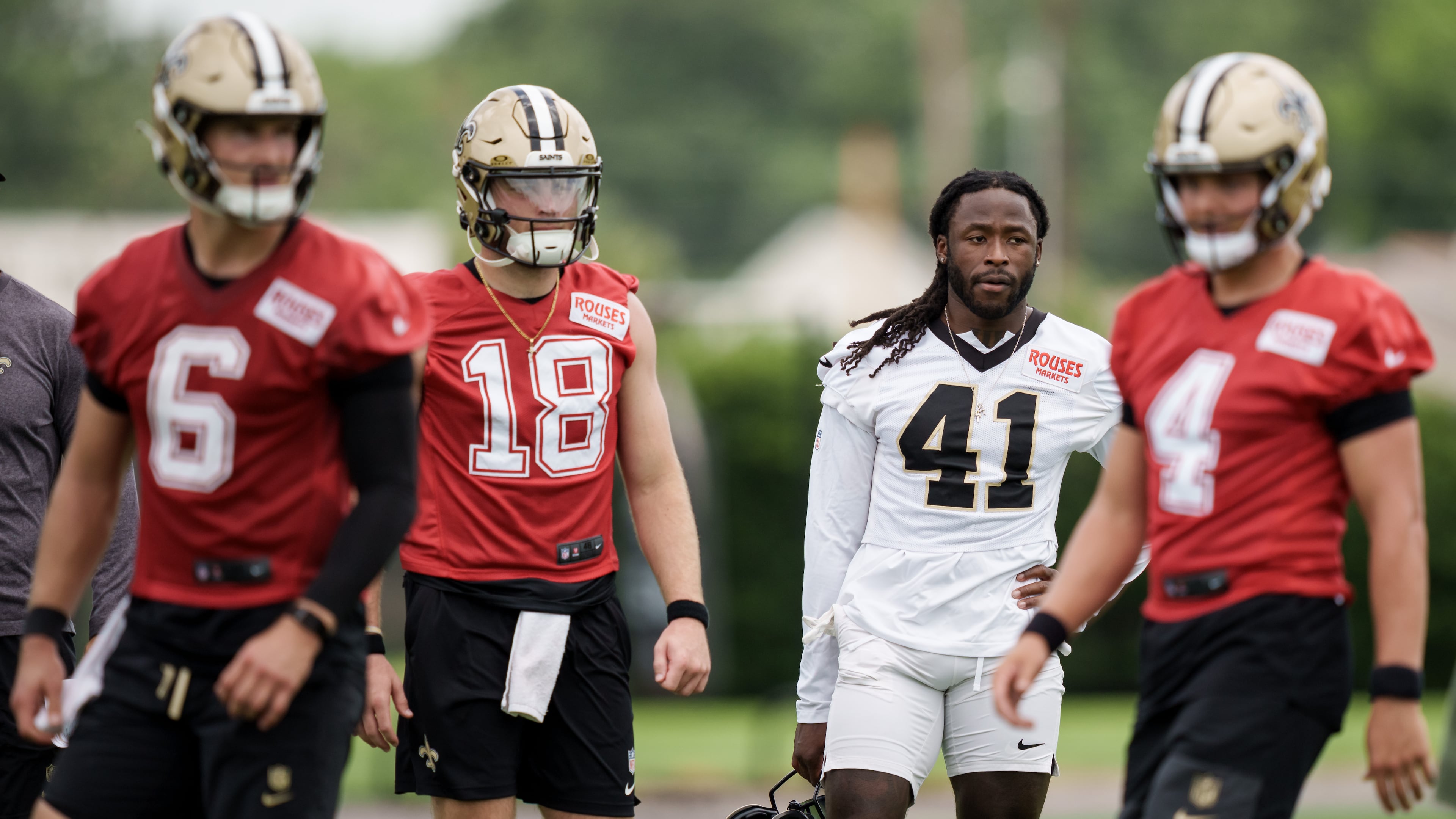 New Orleans Saints running back Alvin Kamara (41), second right, watches practice with quarterback Hunter Dekkers (18), second left, during the NFL football team's practice in Metairie, La., Wednesday, June 17, 2026. (AP Photo/Matthew Hinton)