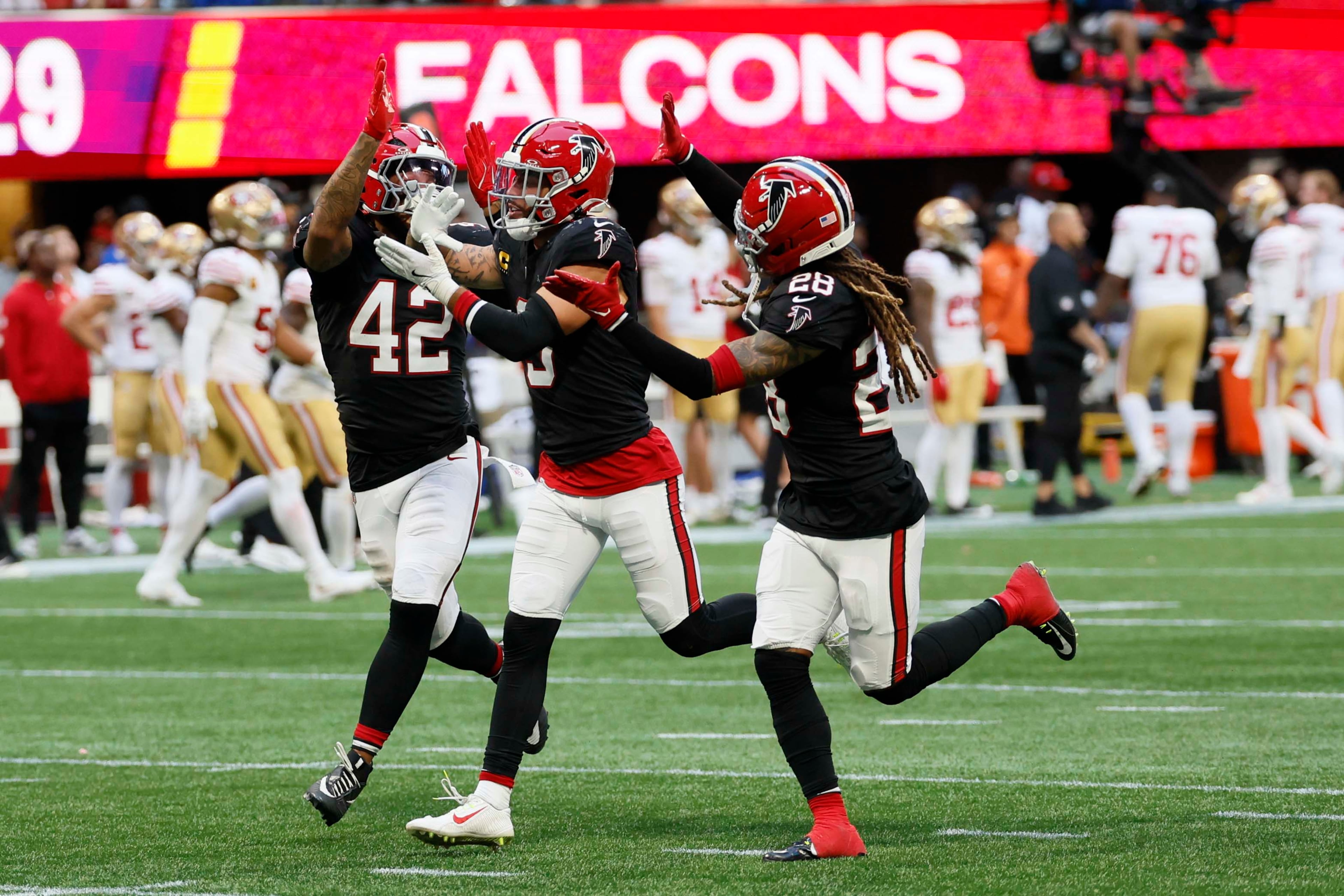 Atlanta Falcons defensive back Mike Ford (28) and linebacker Josh Woods (42) celebrate with safety Jessie Bates (3) after forcing a fumble in the final seconds of the game against the San Francisco 49ers at Mercedes-Benz Stadium in Atlanta, GA, on Sunday, Oct. 25, 2026. The Falcons defeated the 49ers 29-20. (Miguel Martinez/AJC)