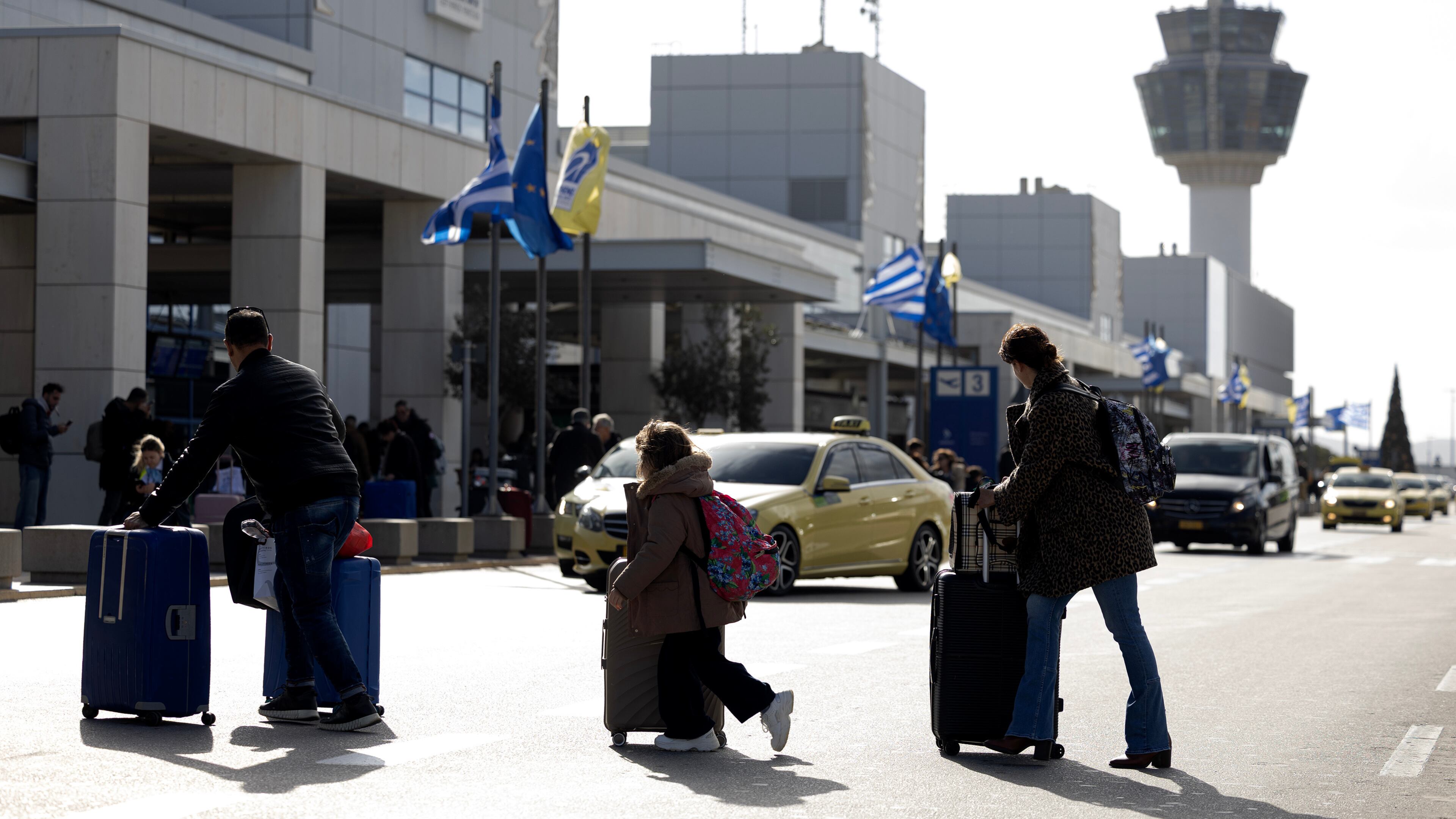 Passengers make their way to Athens' Eleftherios Venizelos international airport in Athens, Greece, Sunday, Jan. 4, 2026, as many flights were disrupted across Greece. (AP Photo/Yorgos Karahalis)