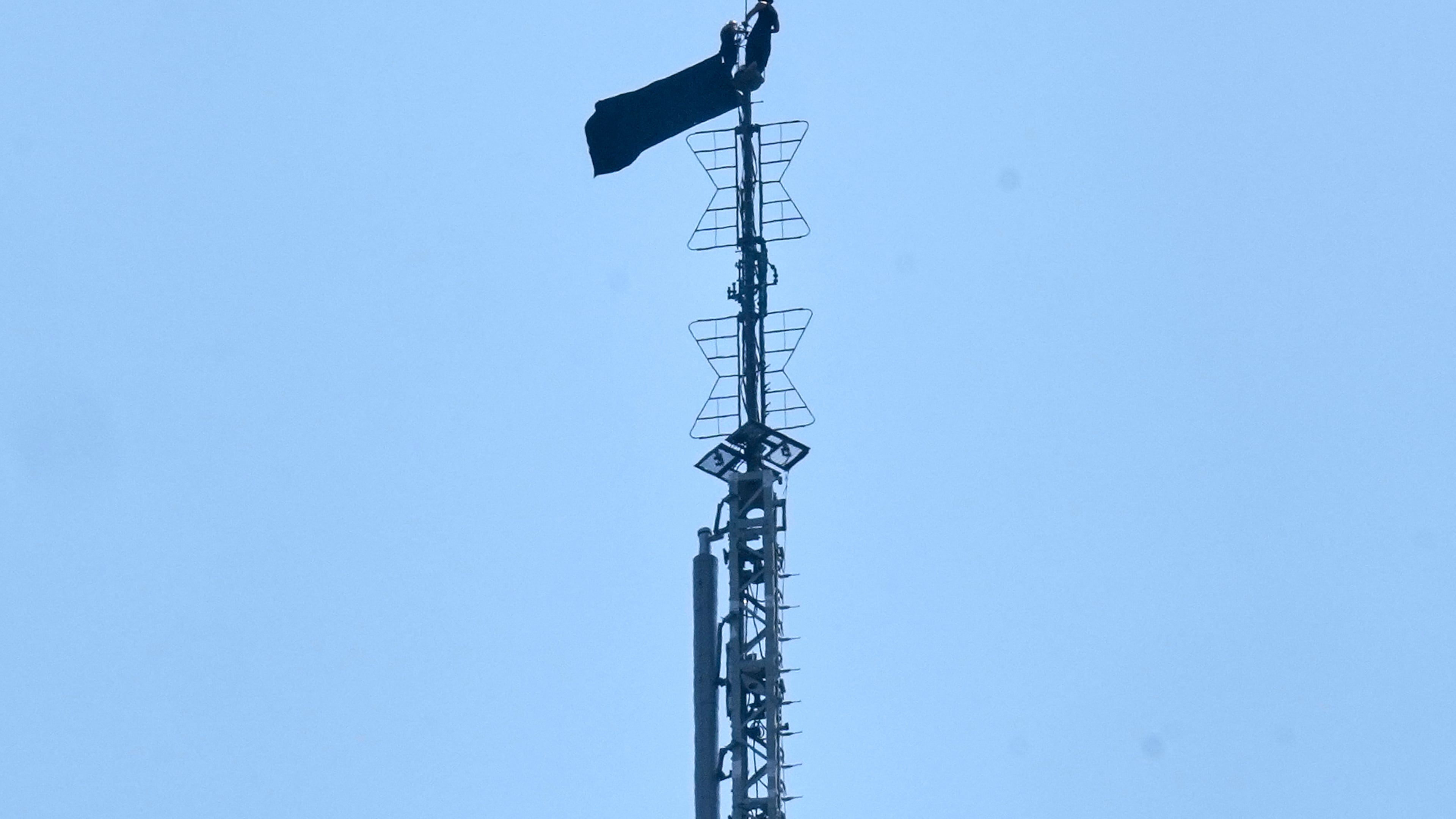 A person is shown atop the spire of the Empire State Building, in New York, Wednesday, July 1, 2026. (AP Photo/Richard Drew)