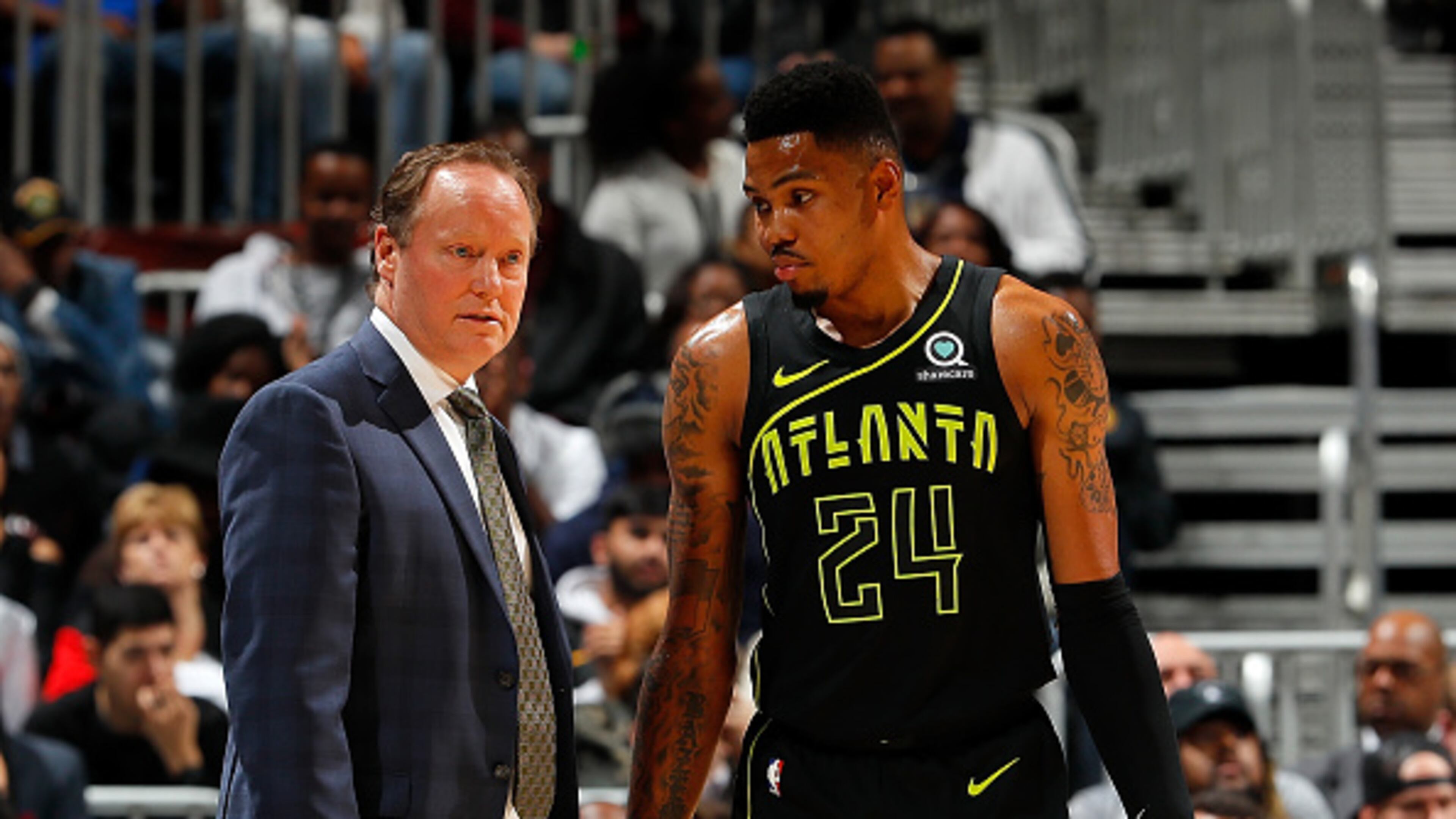 Hawks coach Mike Budenholzer discusses a no doubt difficult situation with Kent Bazemore. (Kevin C. Cox/Getty Images)