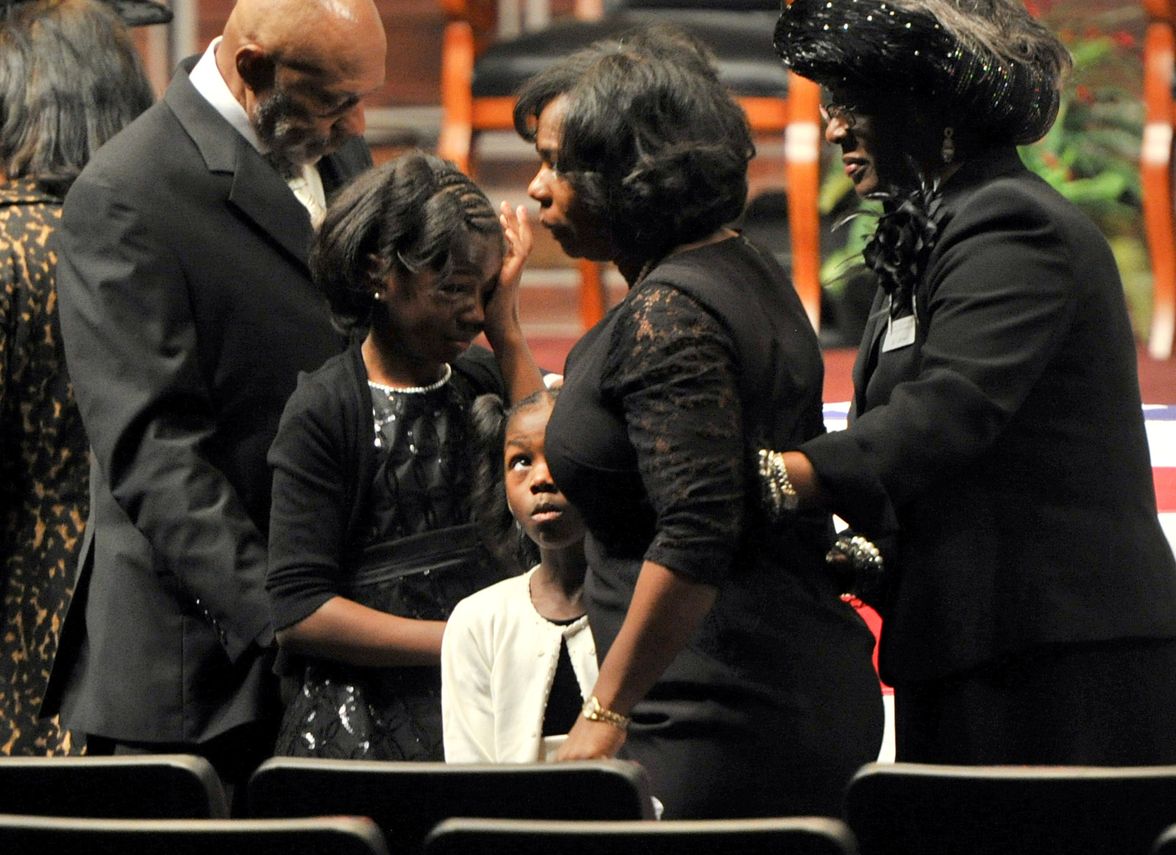 APD Officer Shawn Smiley's daughters Victoria (second from left) and Elizabeth (third from left) watch their mother Terra Smiley (center) walking back to her chair after she touched the casket as her father Thomas Jones comforts her during APD Officer Shawn Smiley's funeral at First Baptist Church of Atlanta on Saturday, November 10, 2012. APD Officer Shawn Smiley was in the passenger seat last weekend when an APD helicopter searching for a missing 9-year-old boy crashed in Atlanta. HYOSUB SHIN / HSHIN@AJC.COM