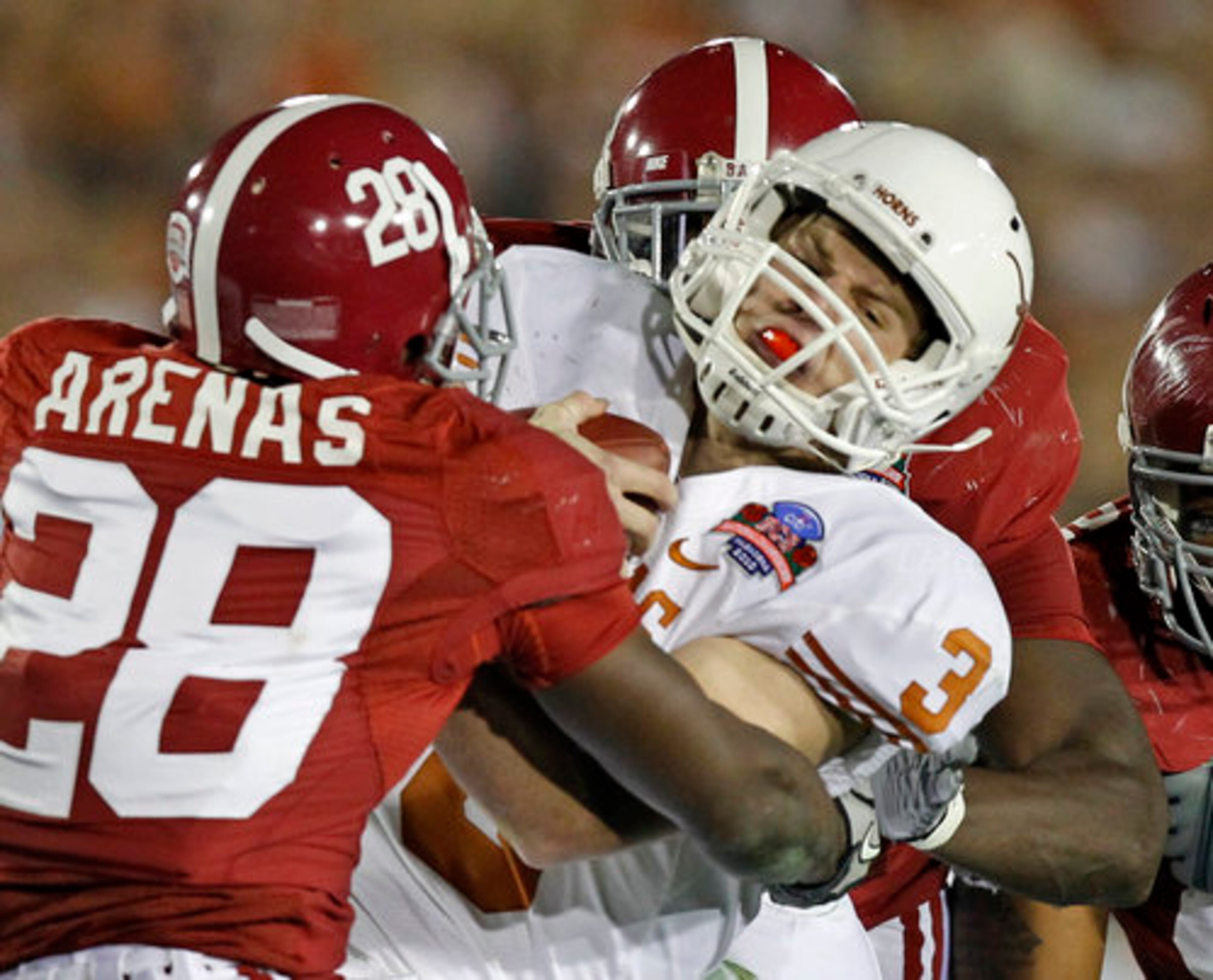 Texas quarterback Garrett Gilbert (3) is sacked by Texas defensive back Mark Fisher (28) and Sam Walker.