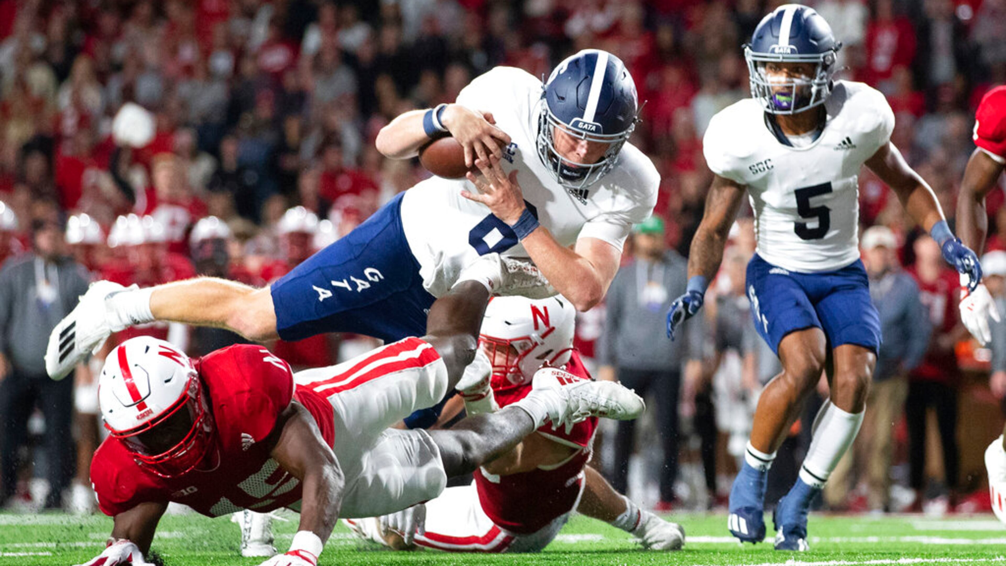 Georgia Southern quarterback Kyle Vantrease (6) leaps over Nebraska's Ernest Hausmann (15) to score a touchdown during the second half of an NCAA college football game Saturday, Sept. 10, 2022, in Lincoln, Neb. Georgia Southern won 45-42. (AP Photo/Rebecca S. Gratz)